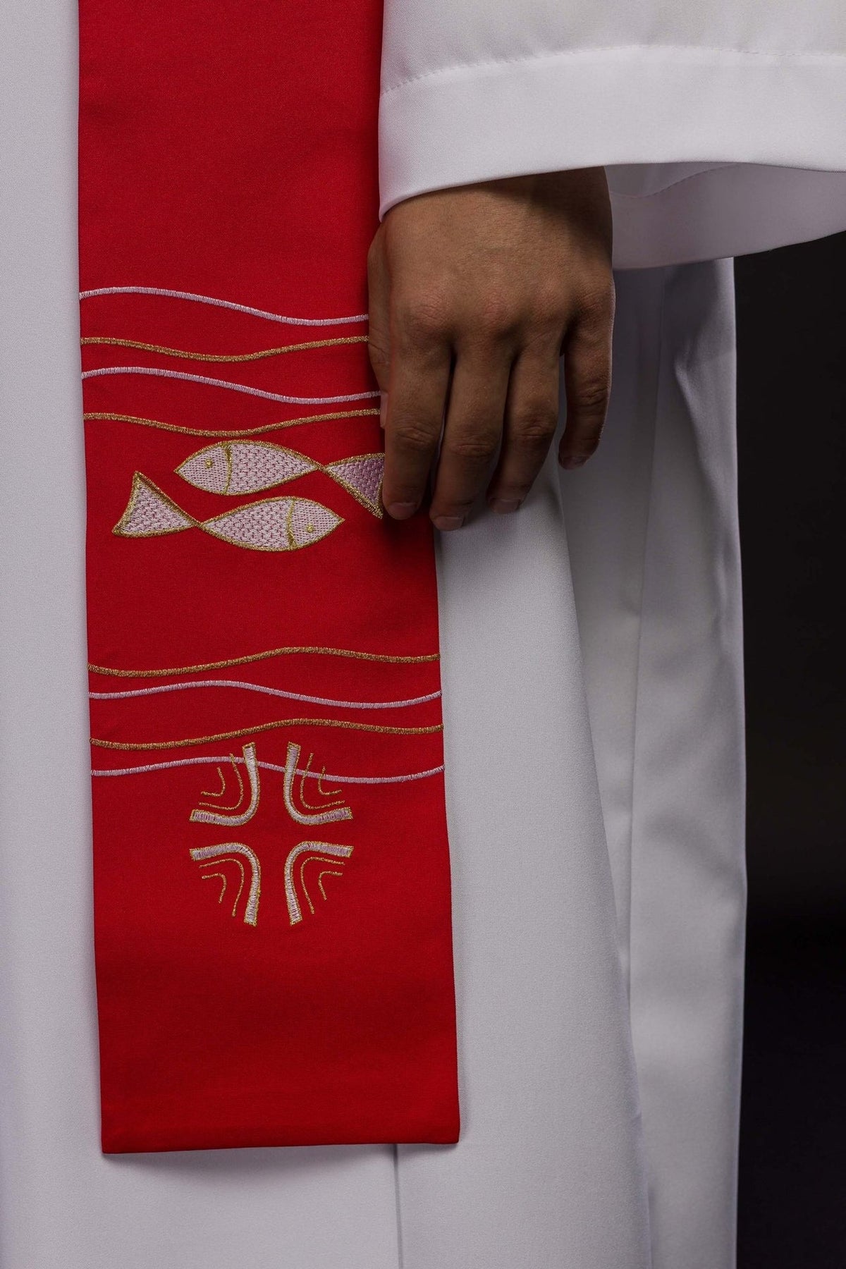 Red stole detail with embroidered fish, cross and wavy lines