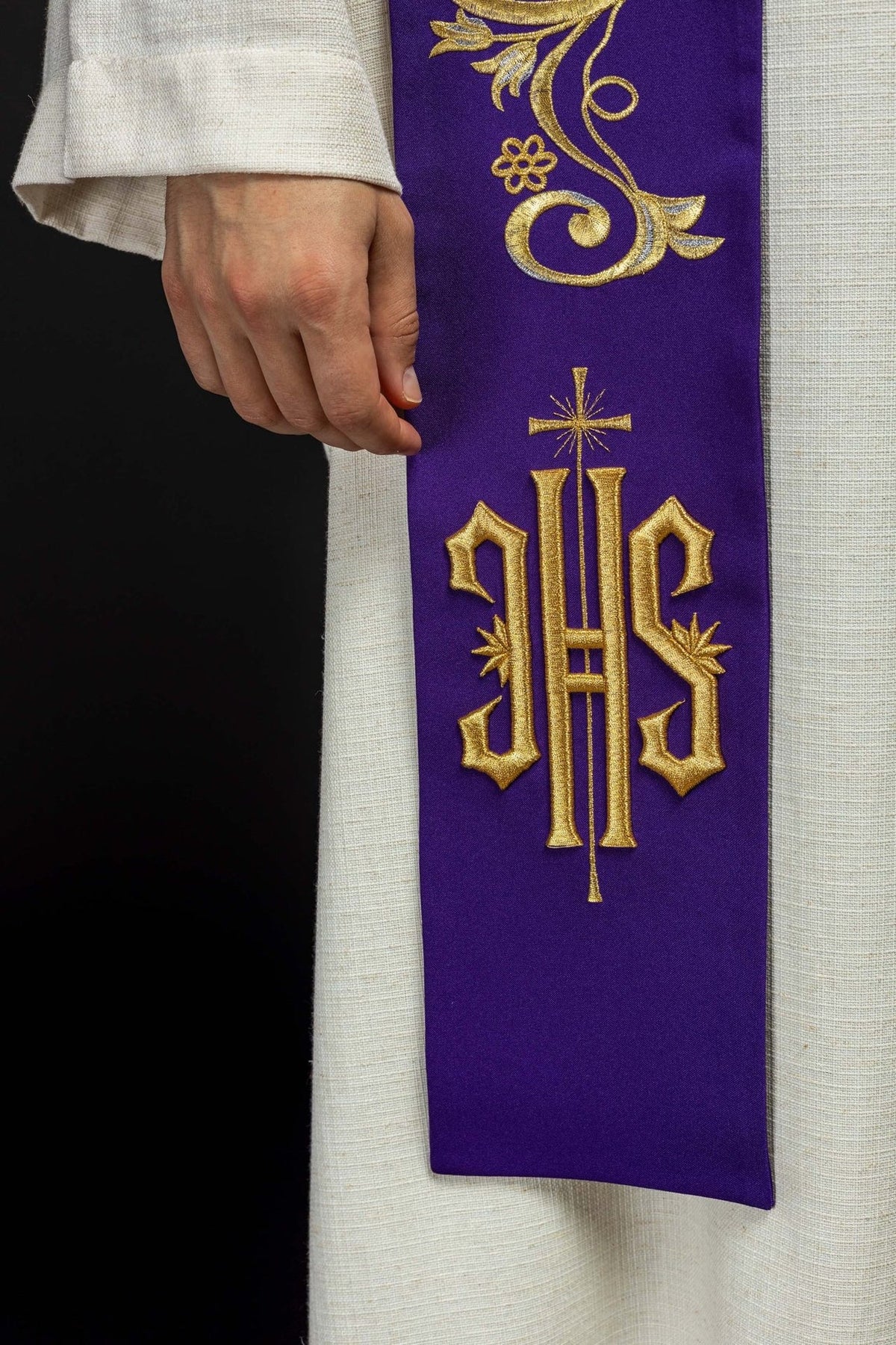 Purple priest stole close-up showing gold embroidered IHS symbol and cross