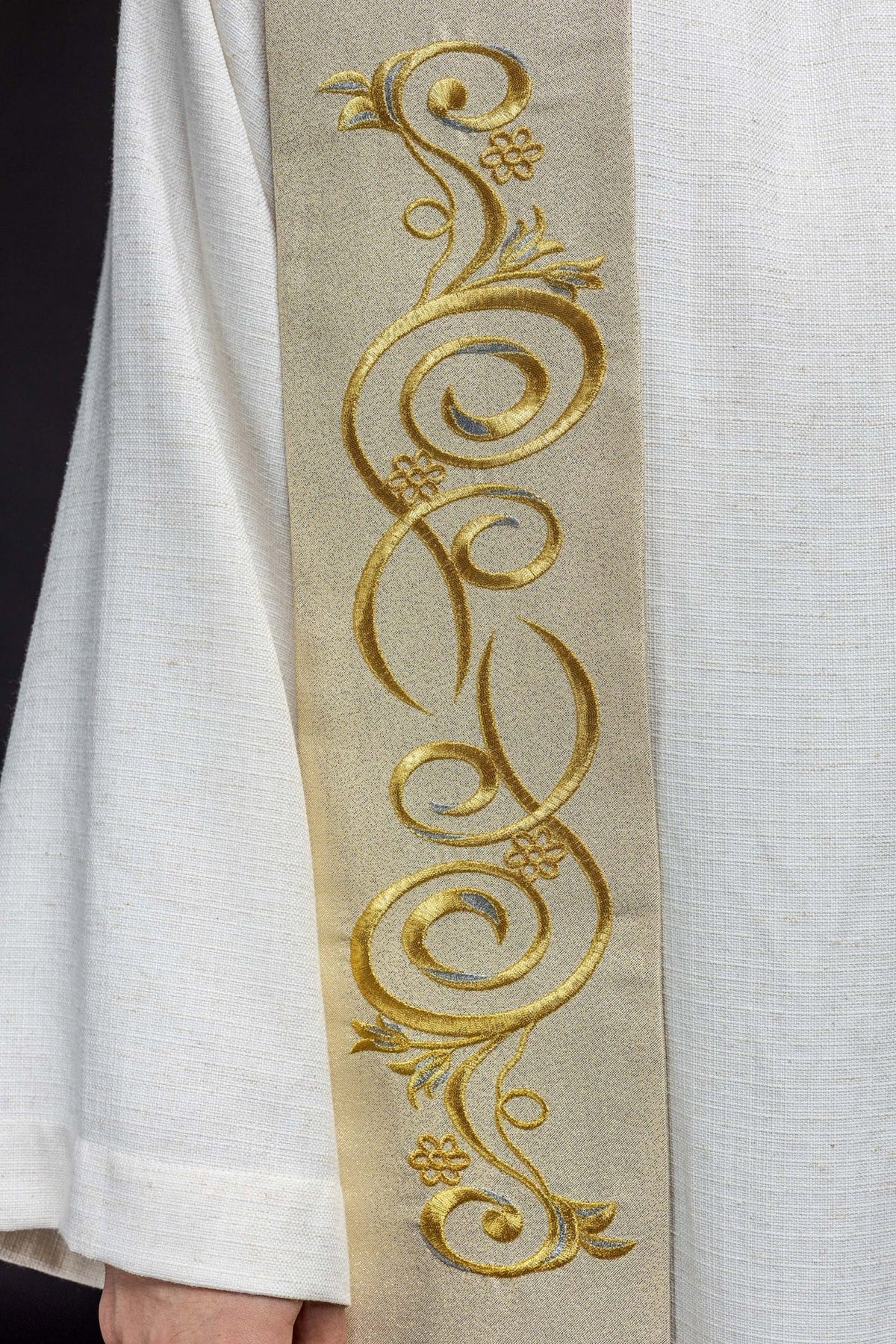 Gold Catholic stole close-up showing repeating floral scroll embroidery