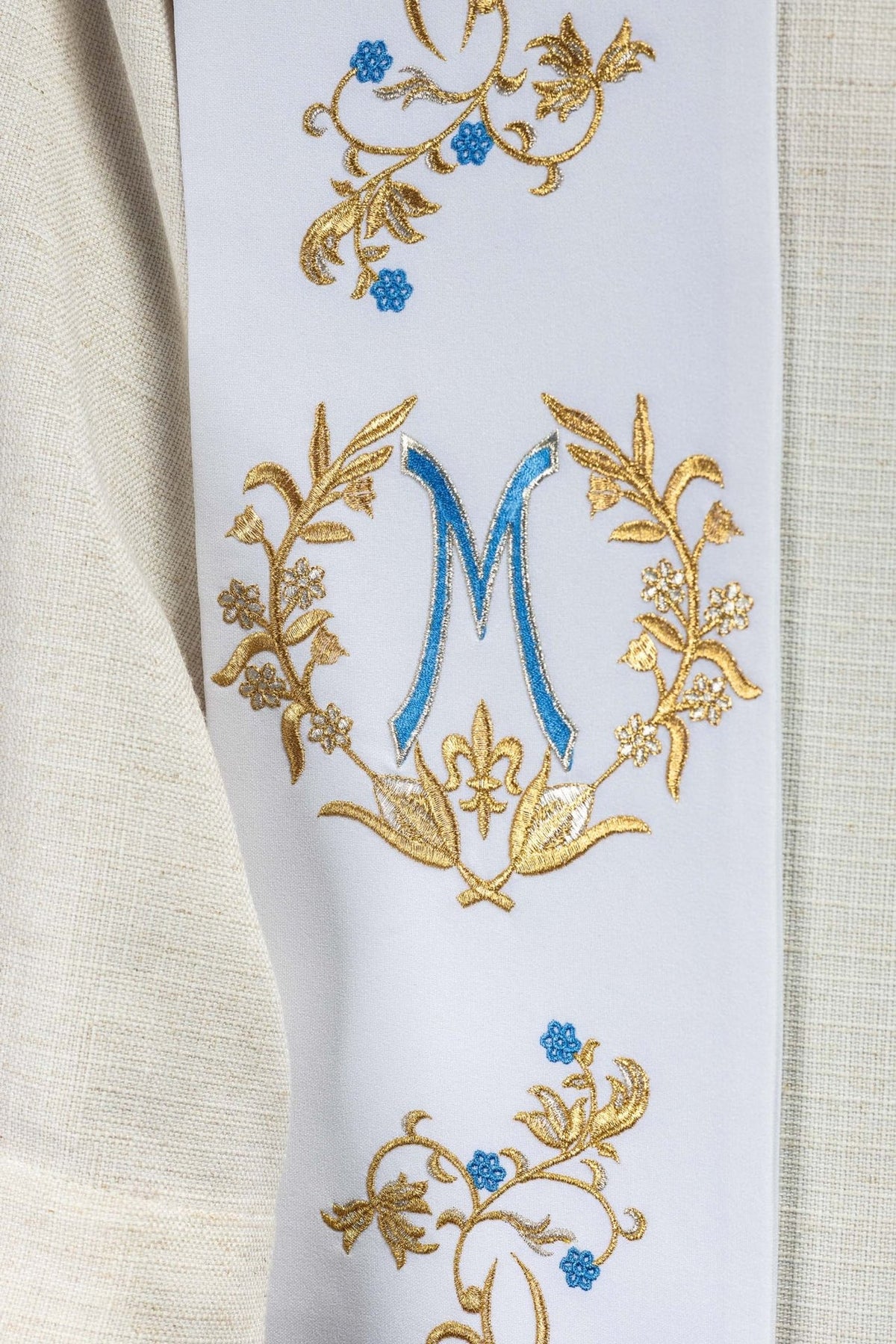 Priest stole close-up showing embroidered Marian symbol in gold and blue