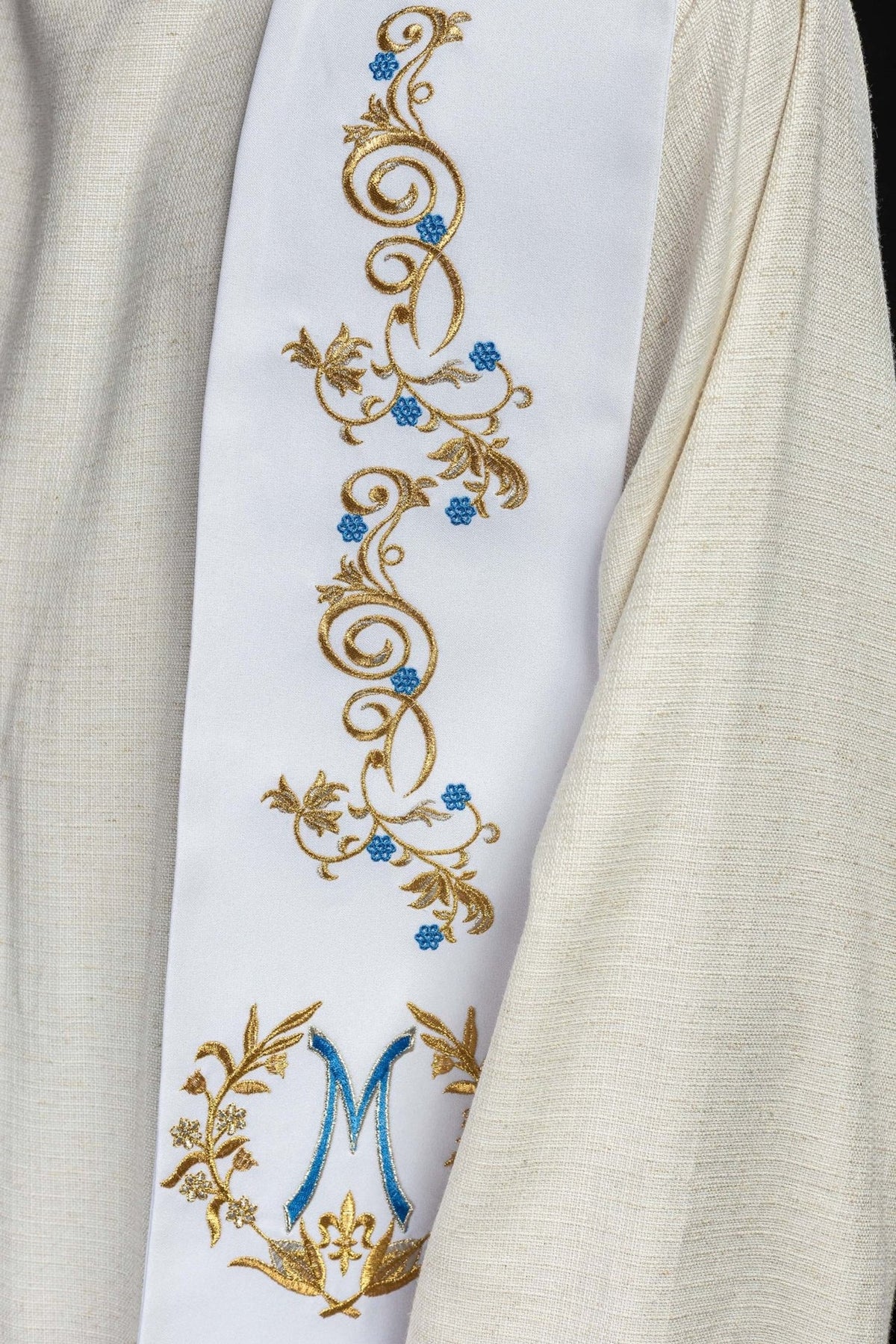 Embroidered priest stole close-up with gold scrollwork and blue floral accents