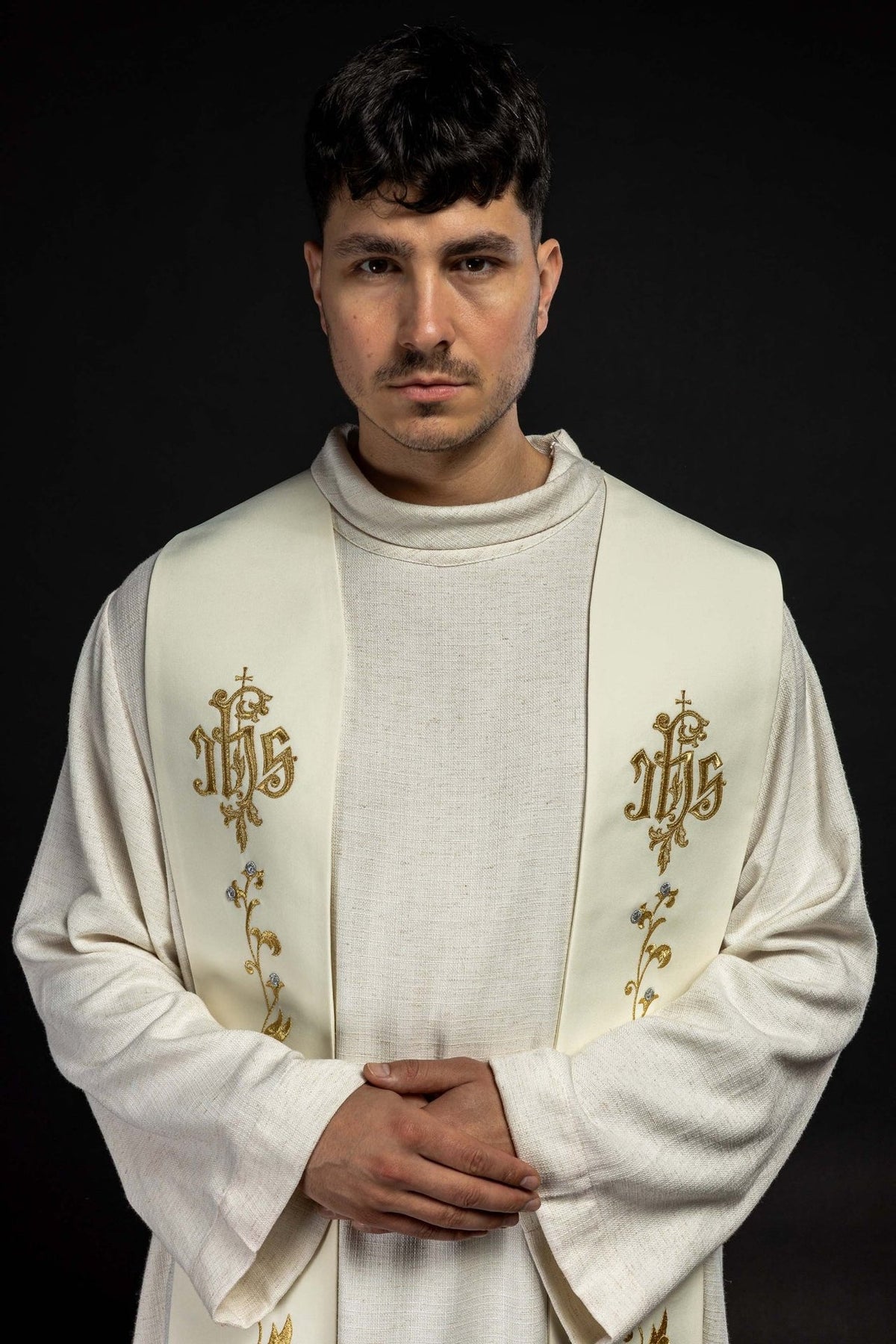 Ecru embroidered stole worn frontally, showing the IHS cross and floral embroidery