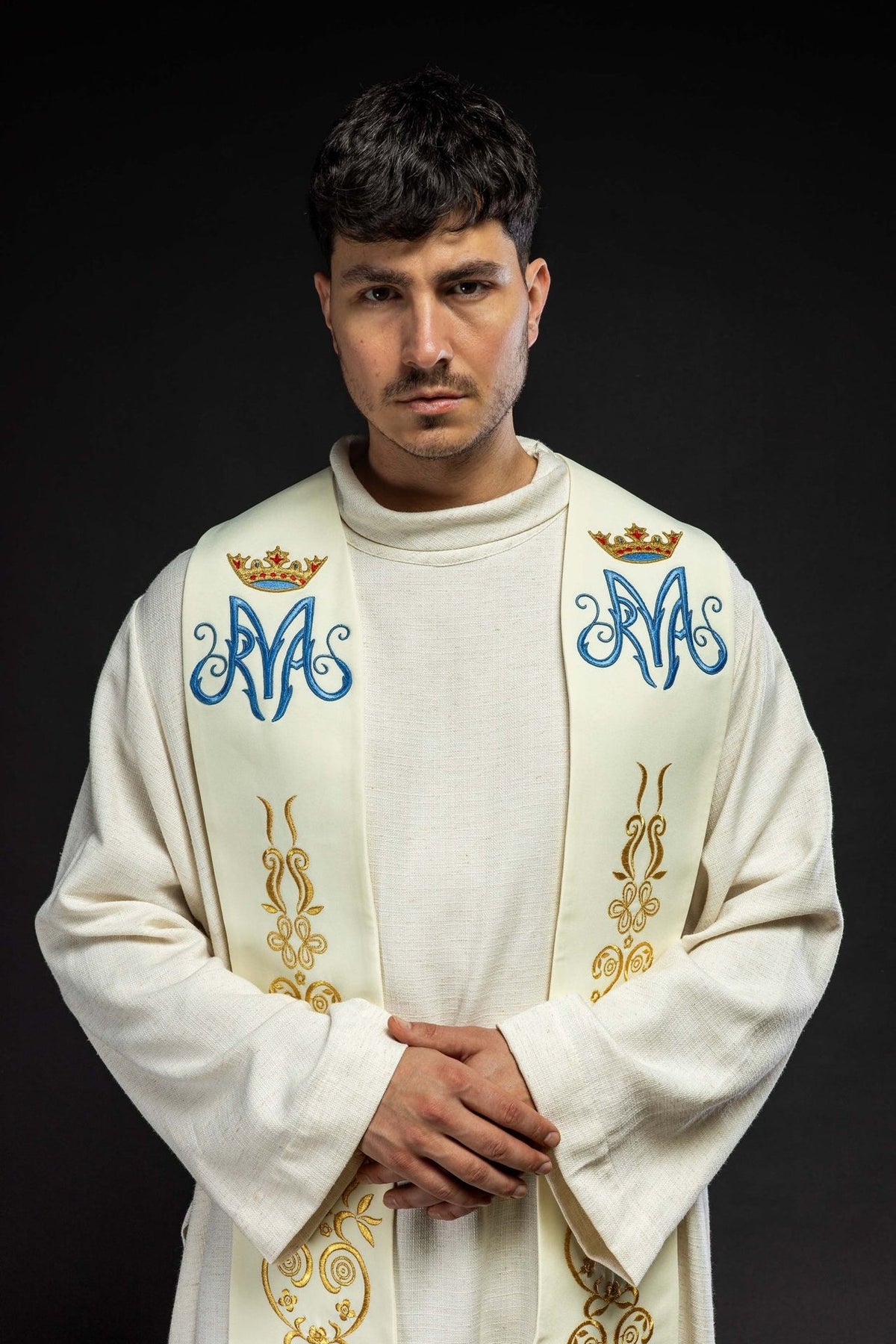 Ecru stole worn close-up showing blue Marian symbols, crowns and gold embroidered motifs