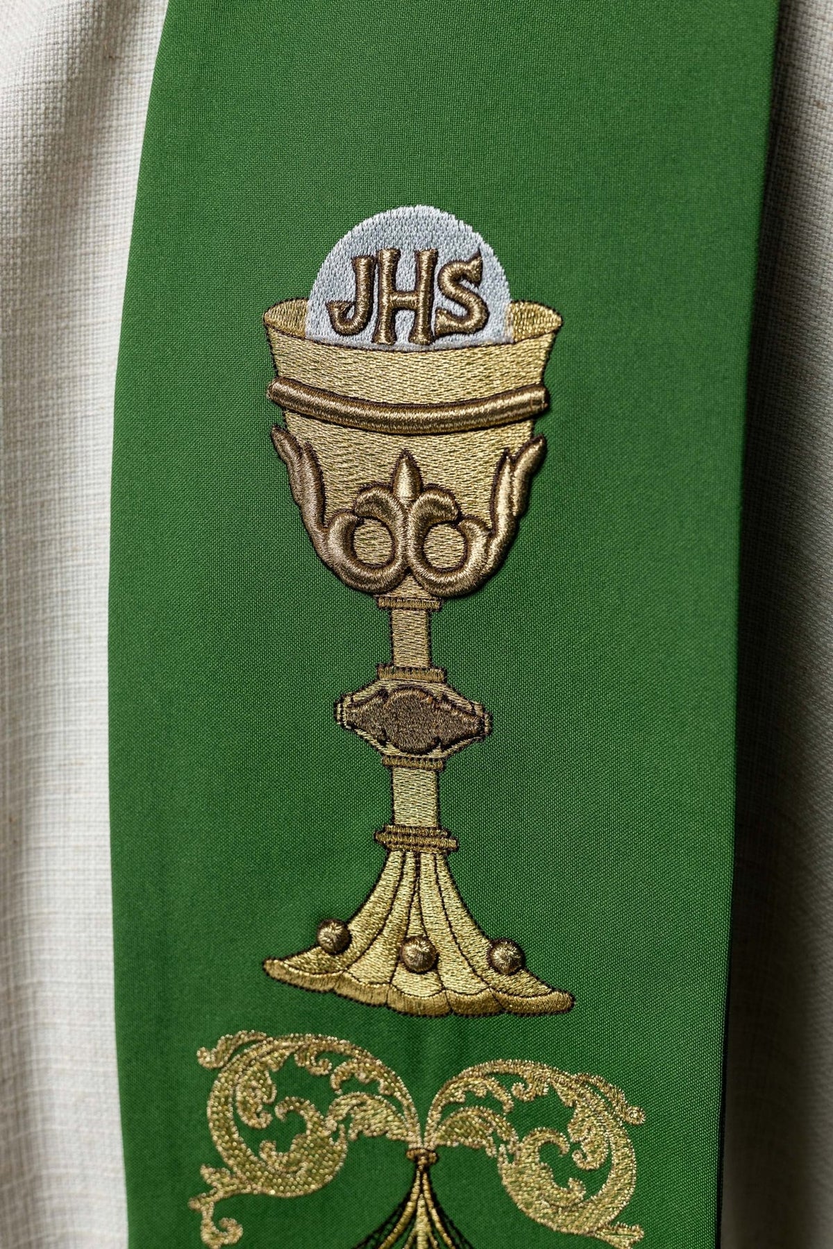 Green priest stole close-up with embroidered IHS and chalice