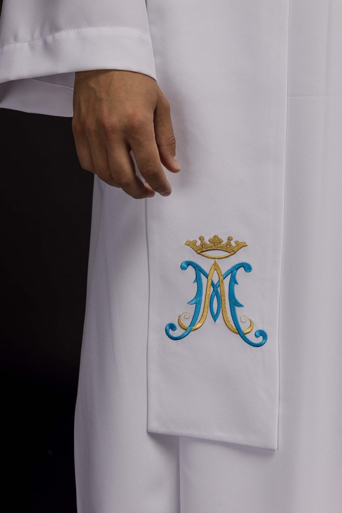 White priest stole close-up with embroidered blue and gold Marian symbol