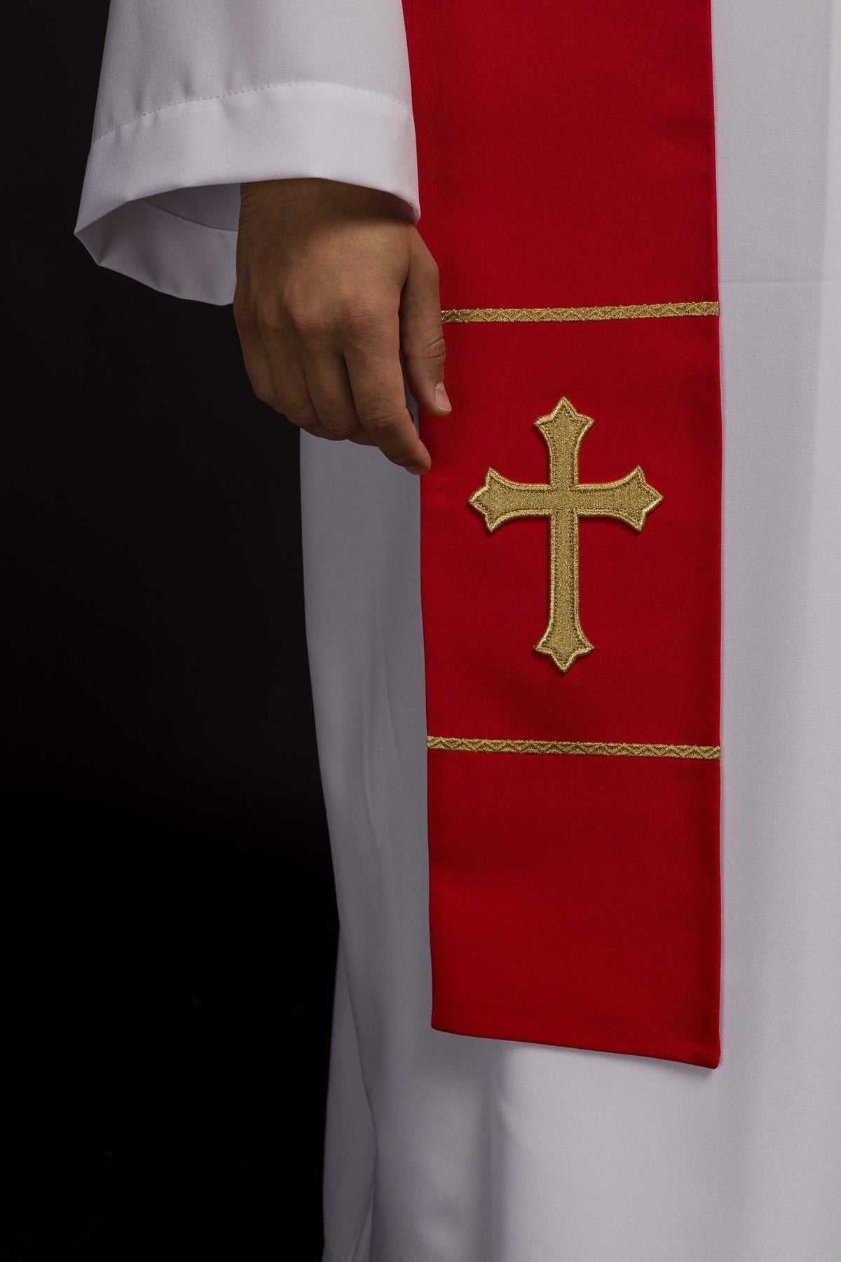 Red stole close-up showing embroidered gold cross and trim