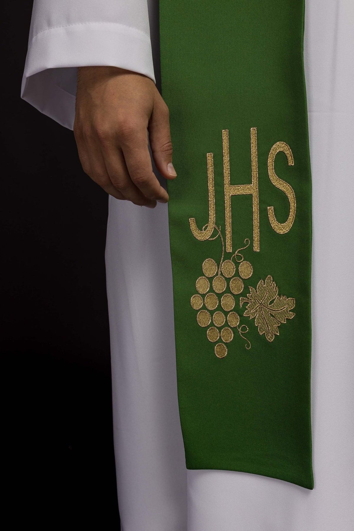 Green priest stole close-up with embroidered IHS and grapes