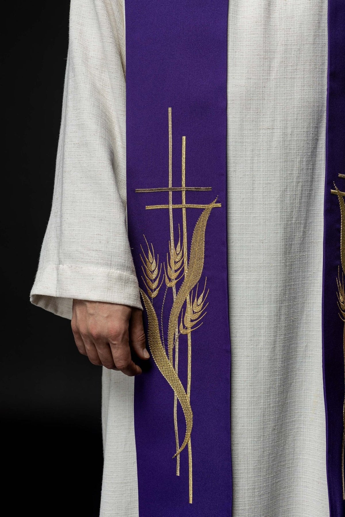 Priest stole close-up showing purple fabric with gold cross and wheat embroidery