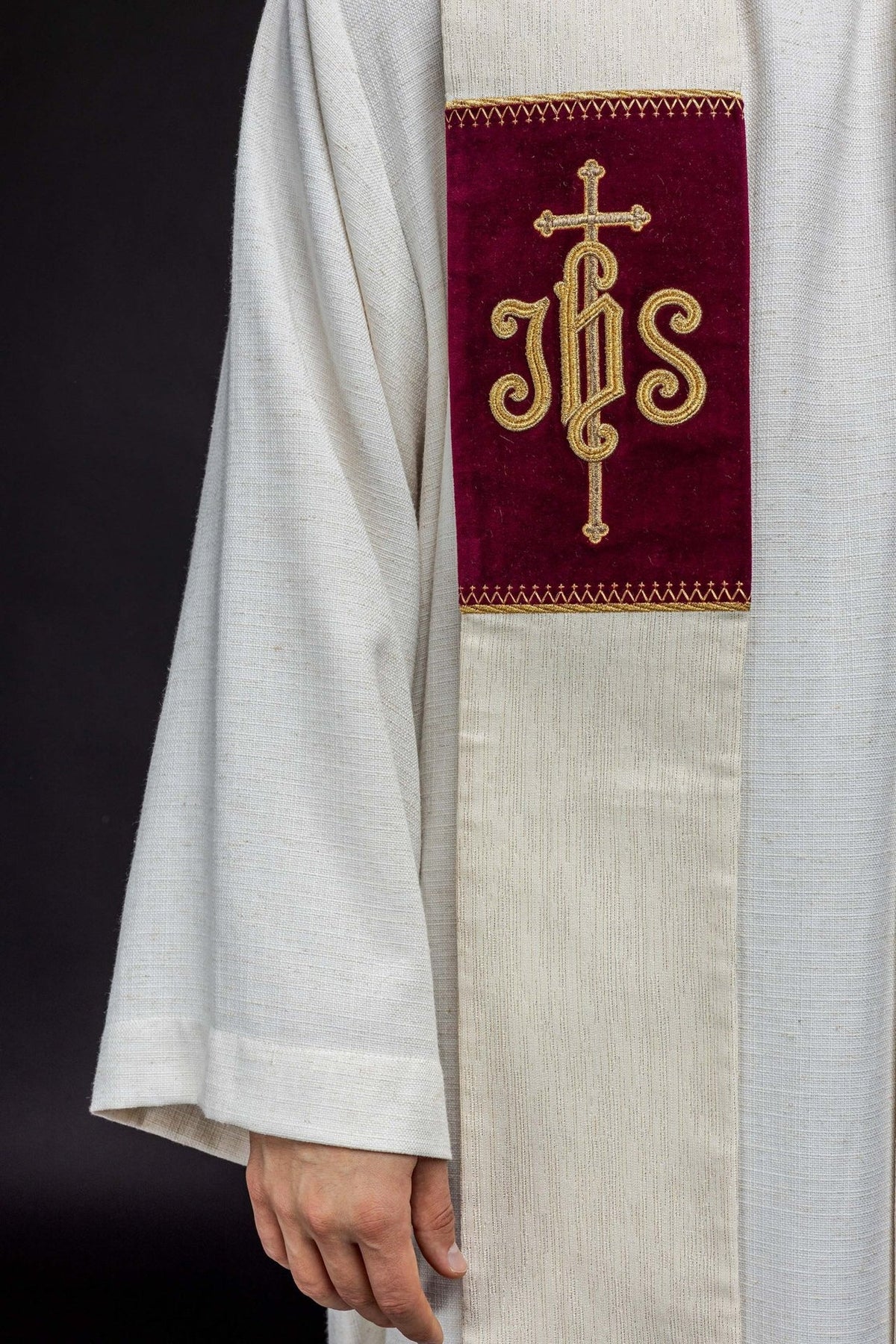 Stole close-up showing gold embroidered JHS symbol on a burgundy panel