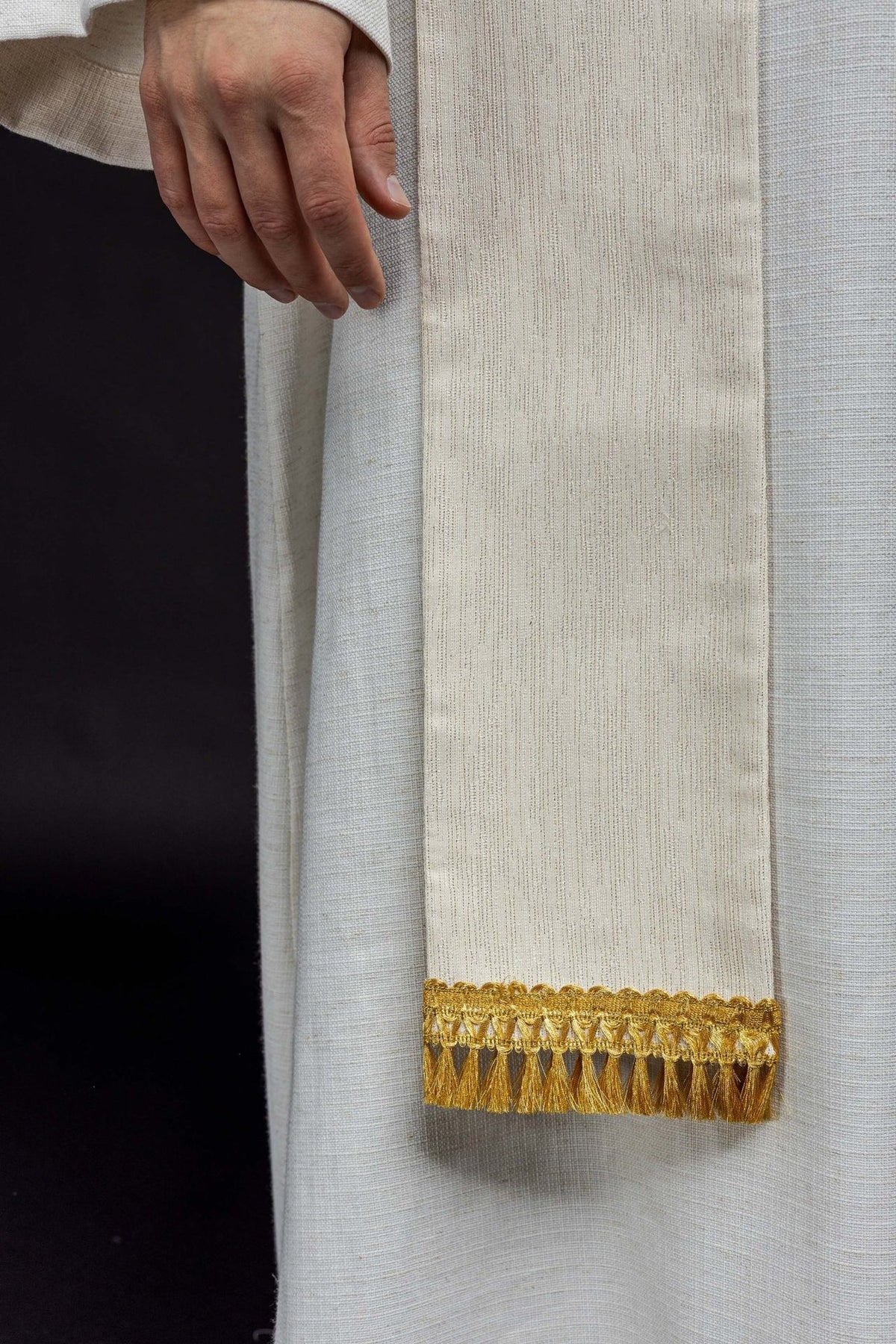 Stole detail showing ivory fabric and gold fringe at the end