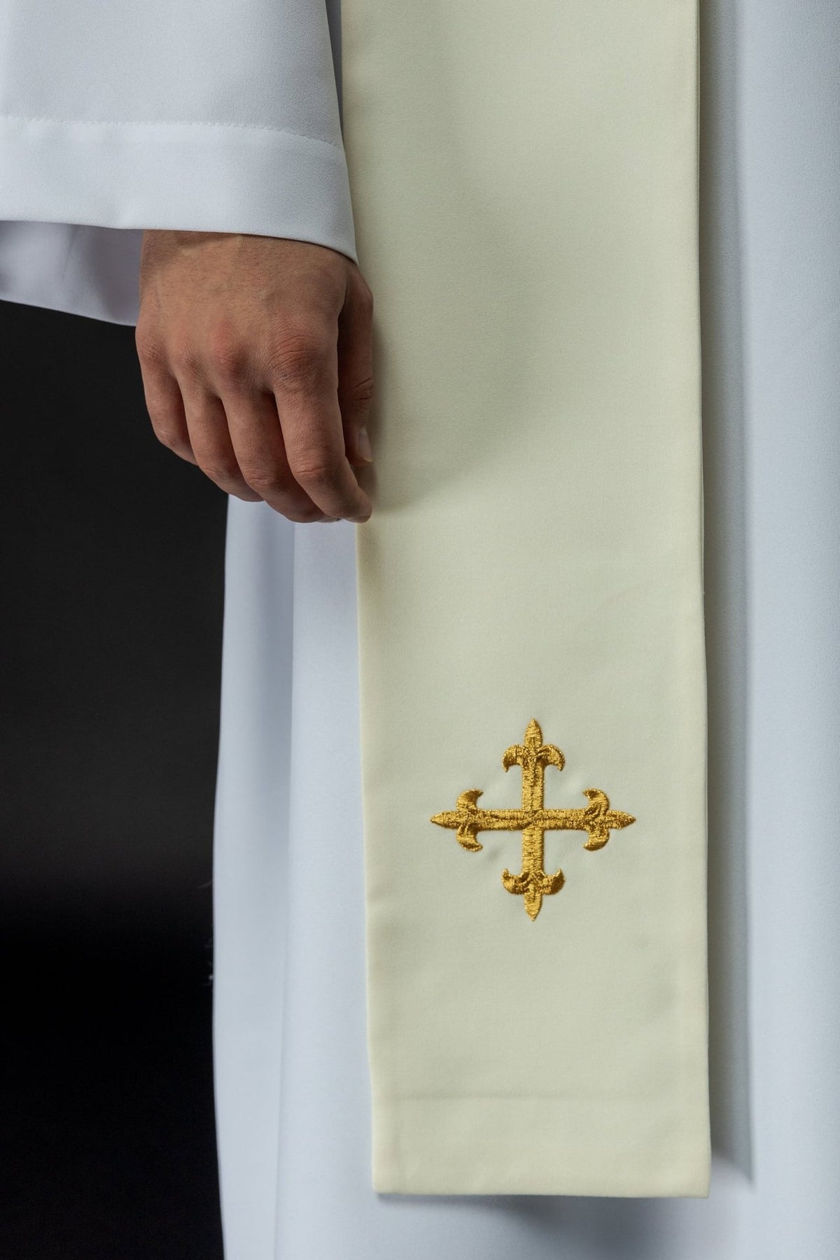 Ecru stole close-up showing embroidered gold cross near the lower end