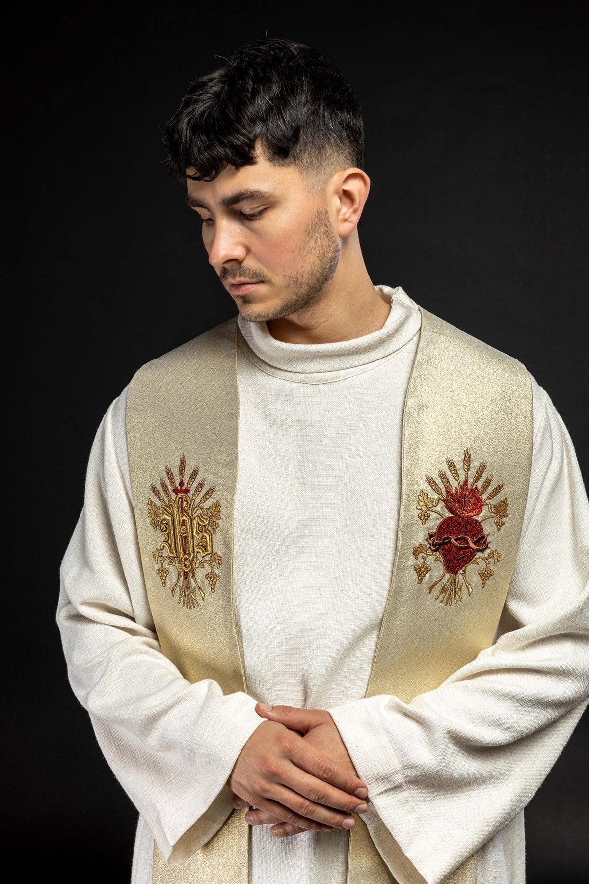 Gold priest stole worn close-up front view with embroidered Sacred Heart of Jesus and monogram