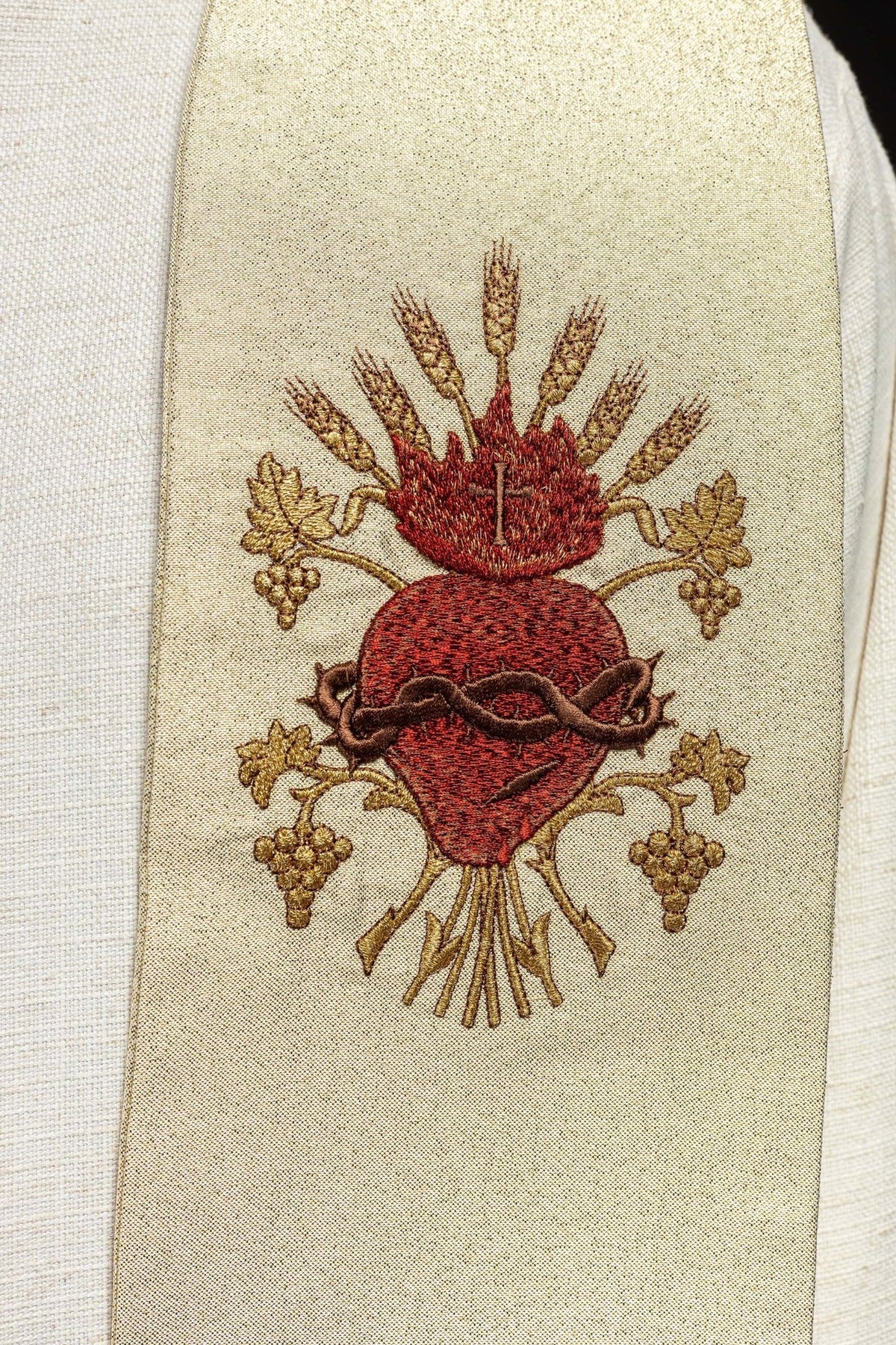 Gold stole close-up showing embroidered Sacred Heart of Jesus with wheat and grape motifs