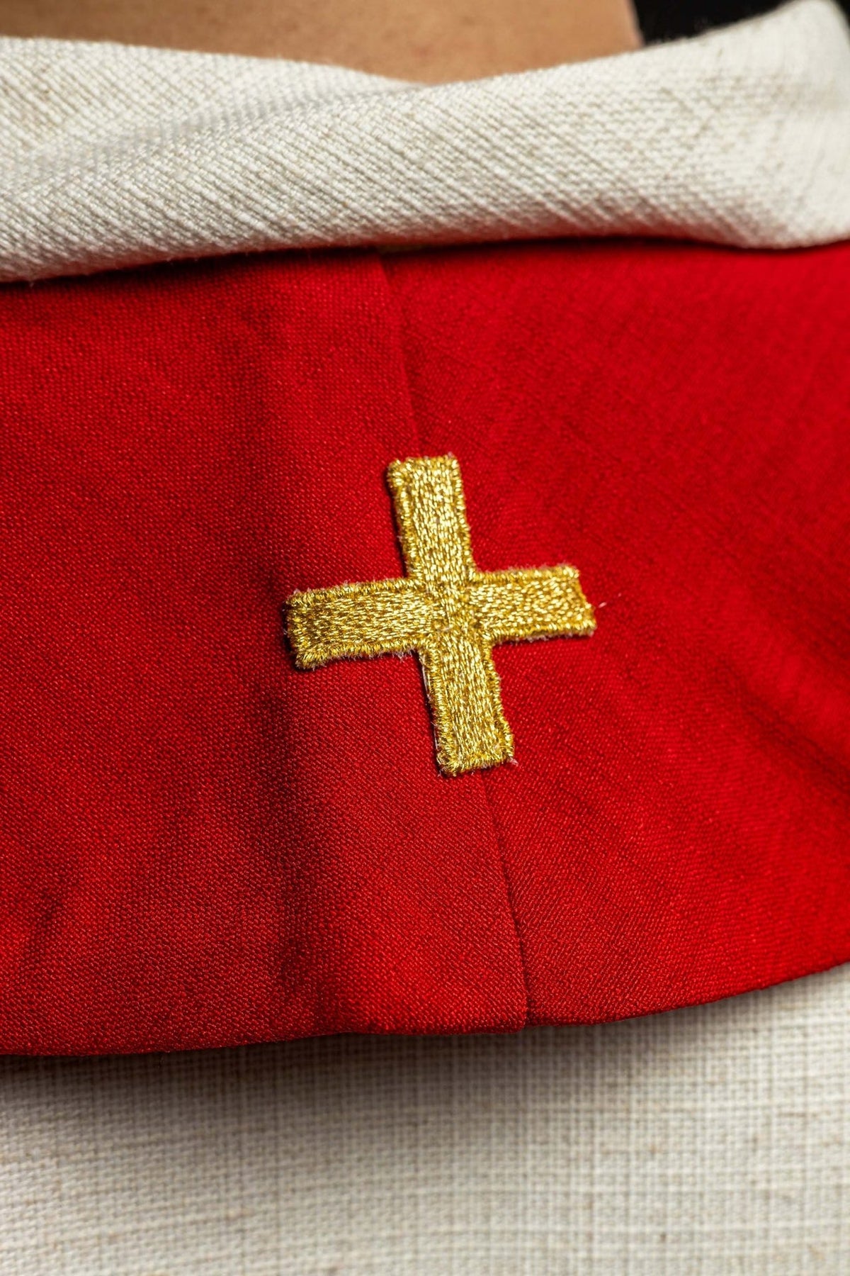 Red stole close-up showing gold embroidered cross