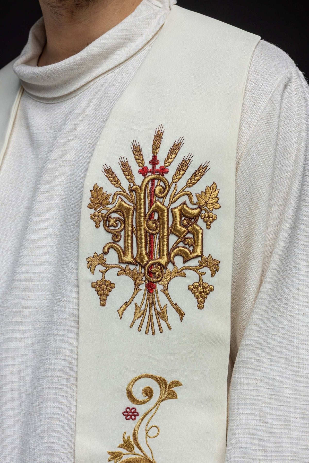 Embroidered stole close-up showing gold IHS, wheat and grape embroidery