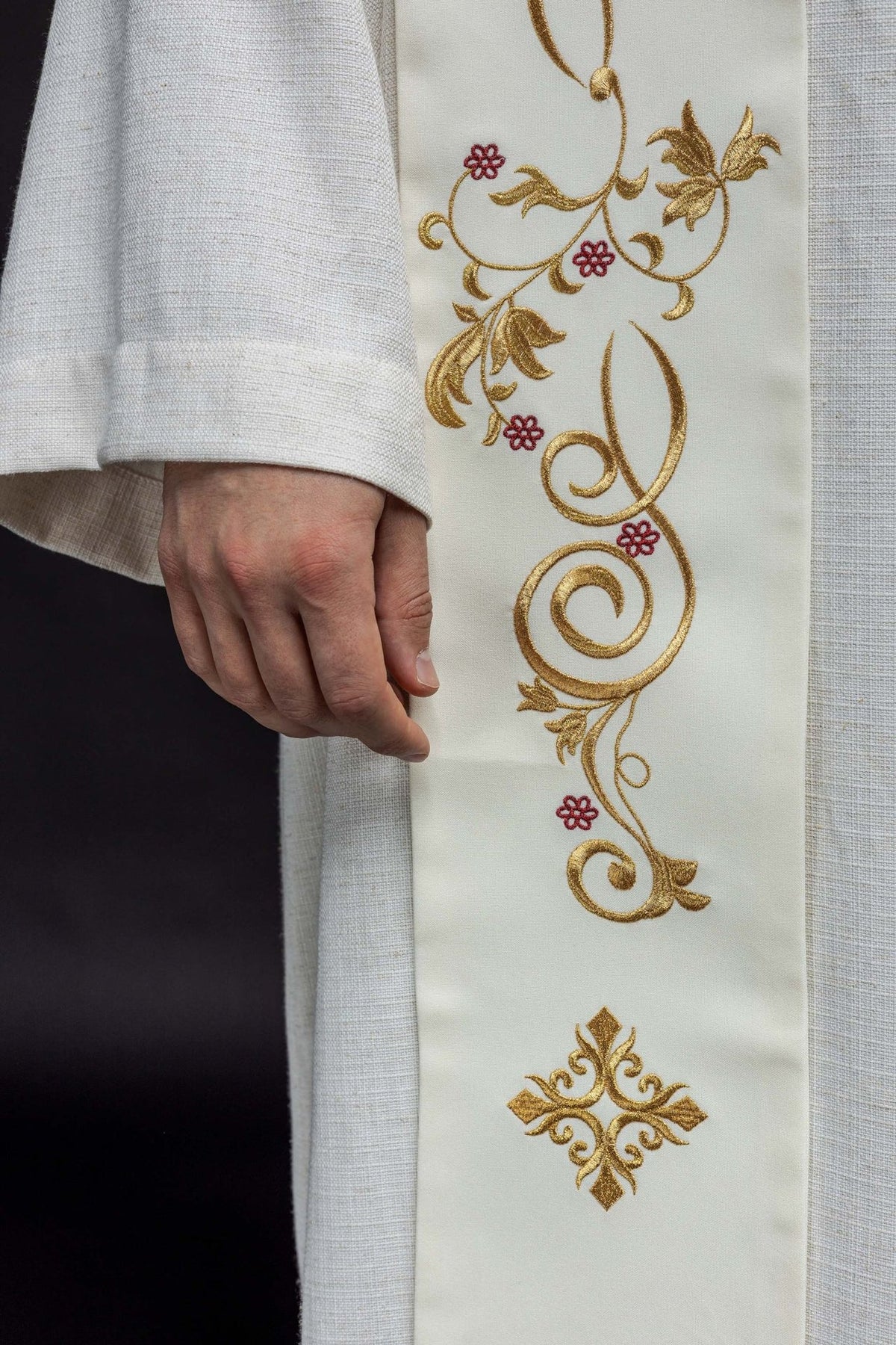 Embroidered stole detail showing gold scroll, leaf and red flower embroidery