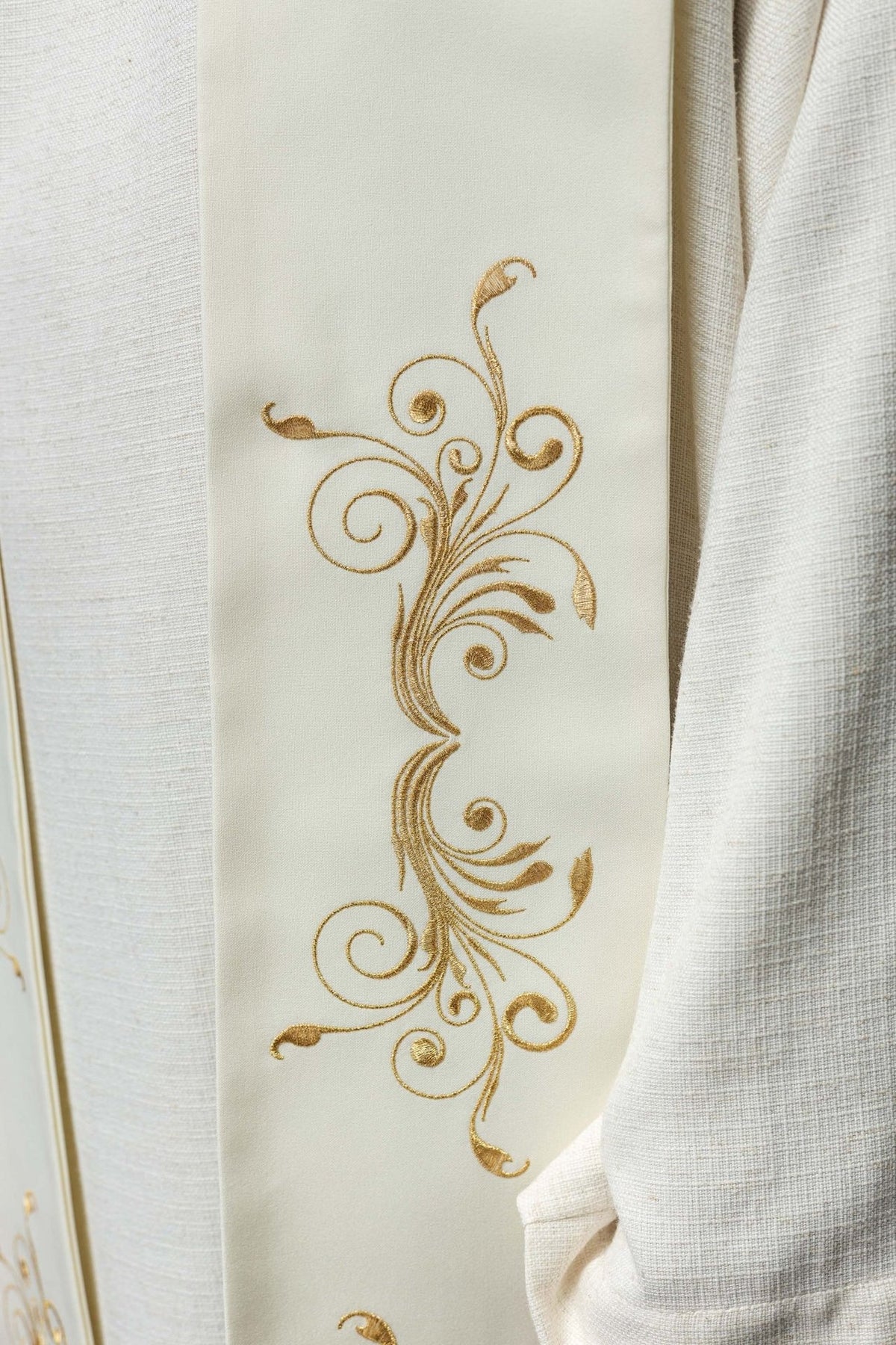 Ecru stole close-up showing ornate gold scroll embroidery