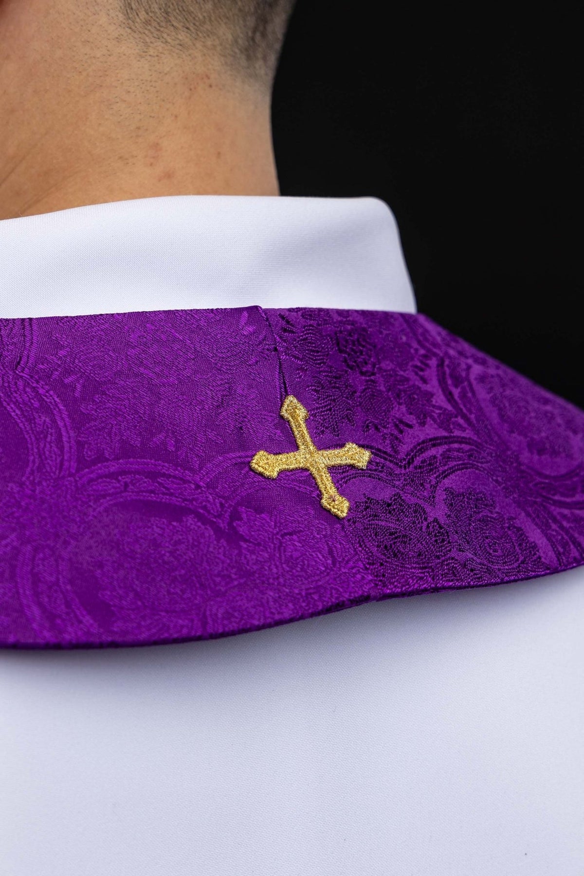 Purple priest stole close-up showing a small gold embroidered cross