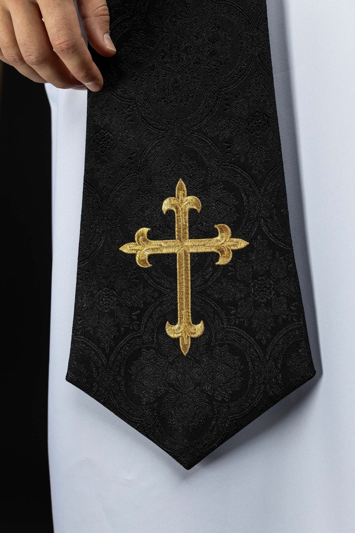 Black priest stole close-up with gold embroidered cross and jacquard fabric