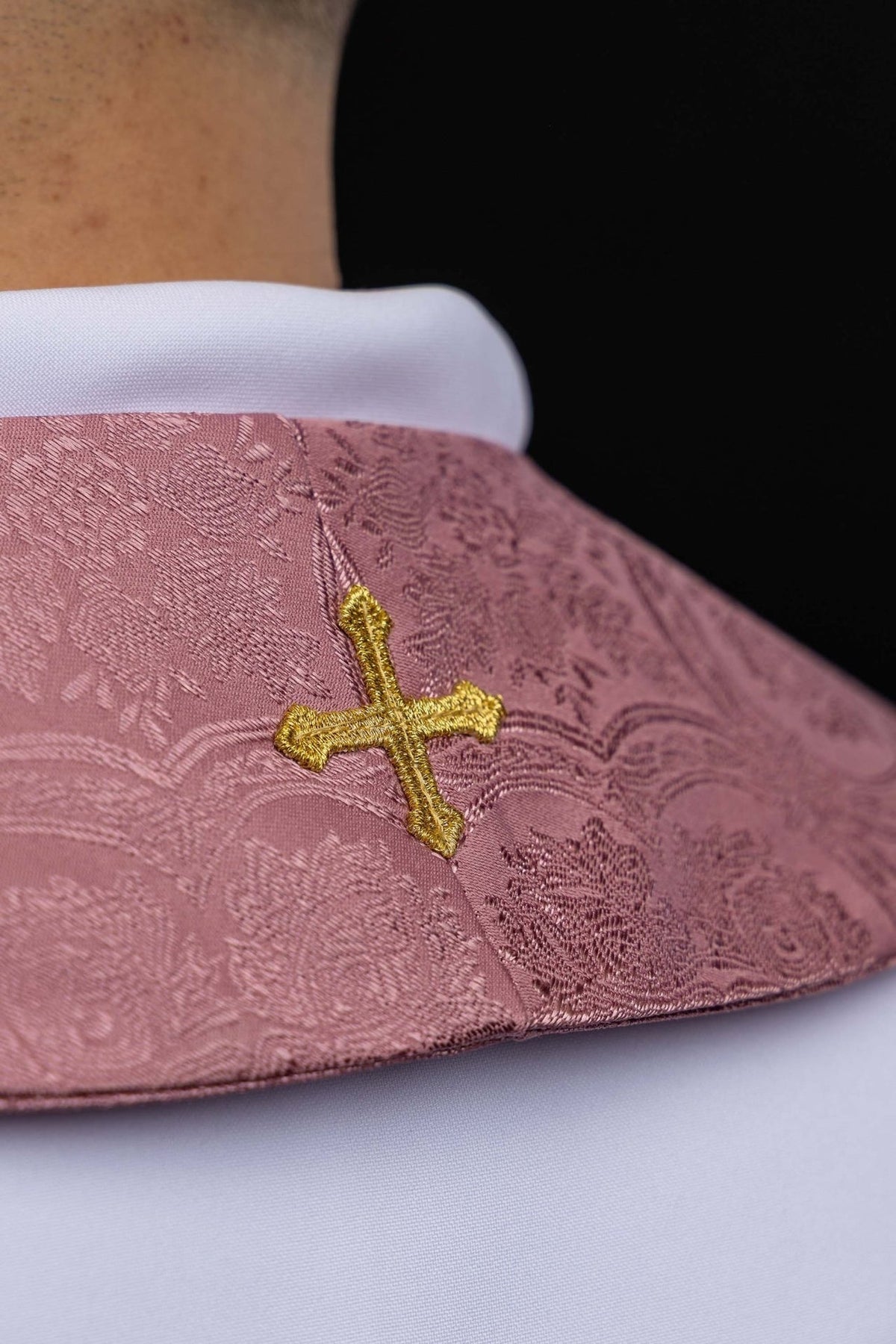 Rose stole detail showing gold embroidered cross and jacquard fabric