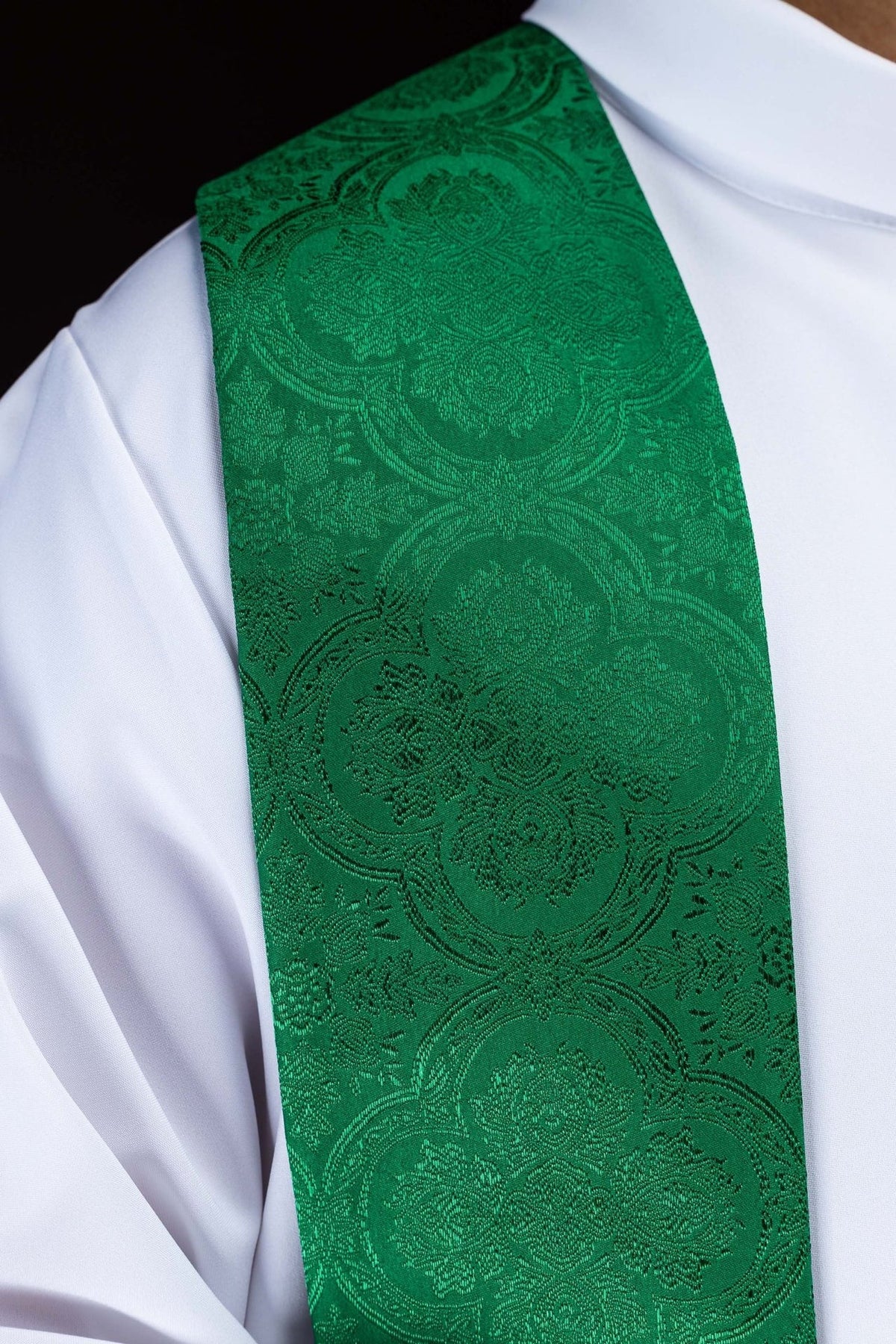Green stole close-up showing embroidered jacquard fabric and floral motifs