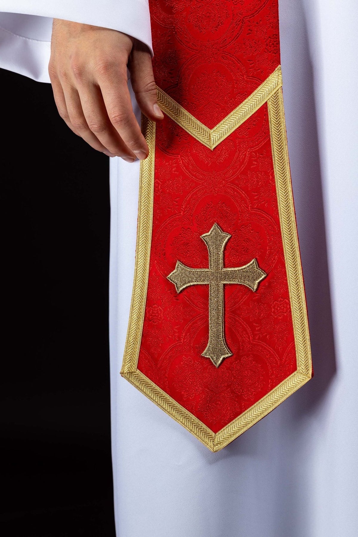 Red priest stole detail with embroidered gold cross and pointed end