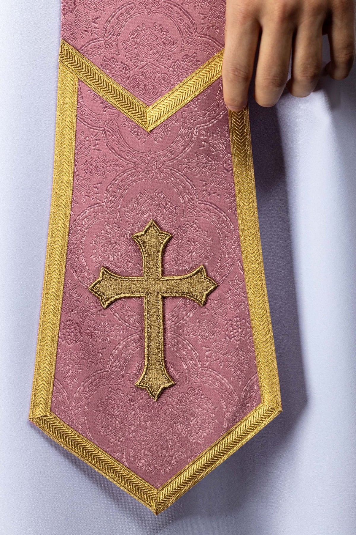 Rose stole close-up showing gold cross, gold edging and jacquard floral motifs
