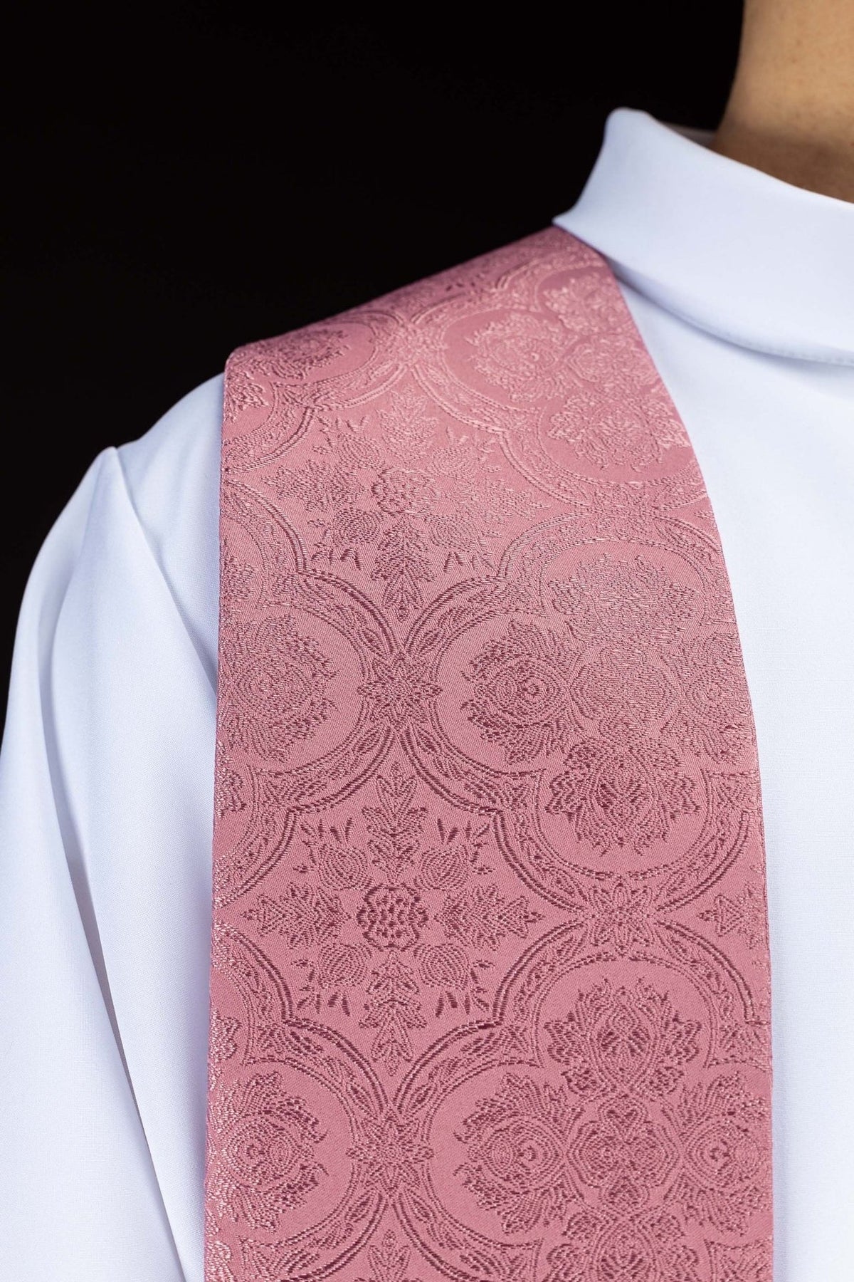 Rose stole worn over an alb, showing the jacquard floral pattern without visible cross