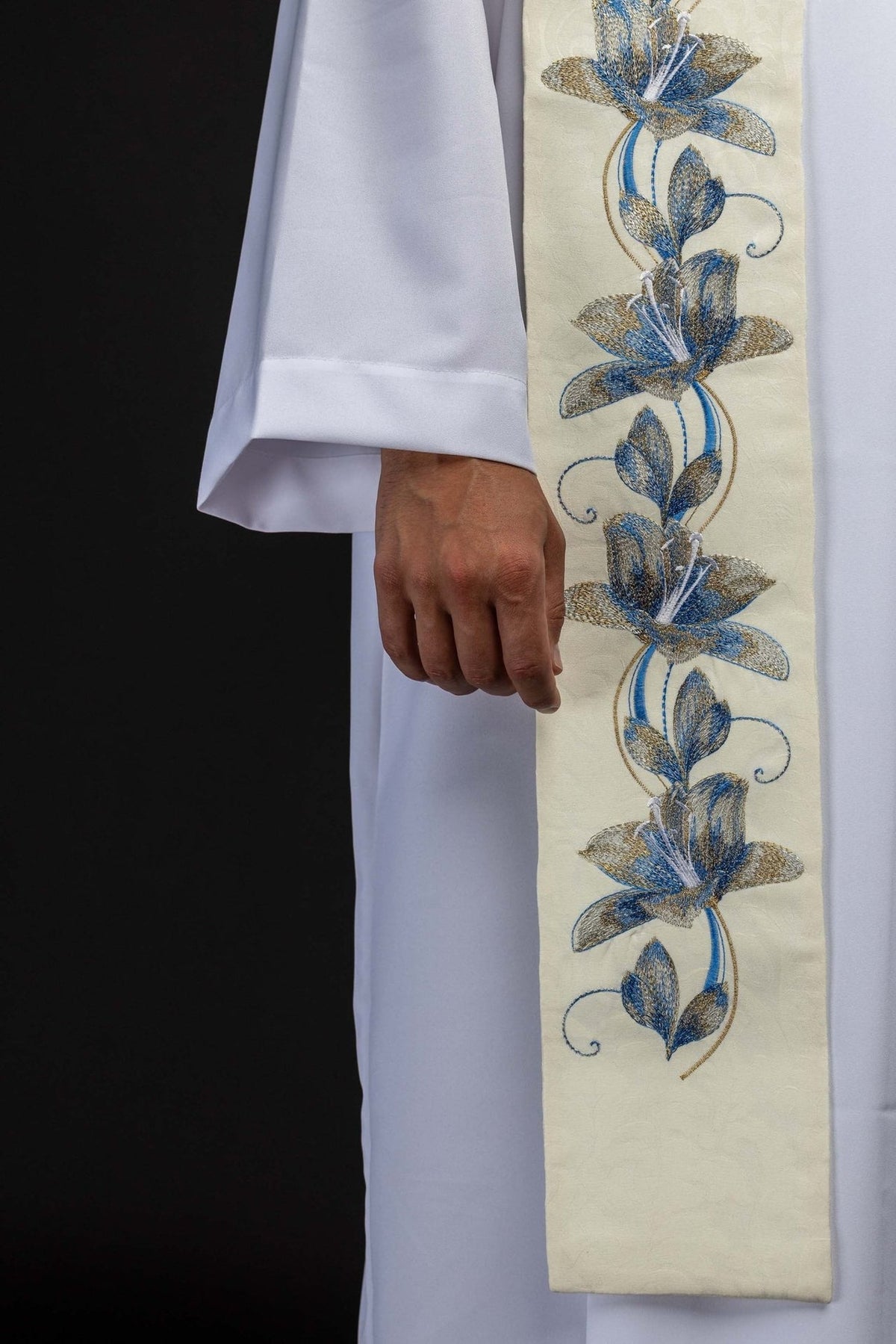 Stole side close-up showing blue and gold embroidered floral vine on ecru fabric