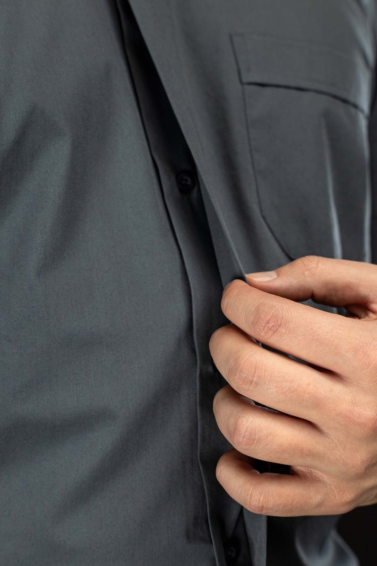 Dark gray clergy shirt close-up of front button placket