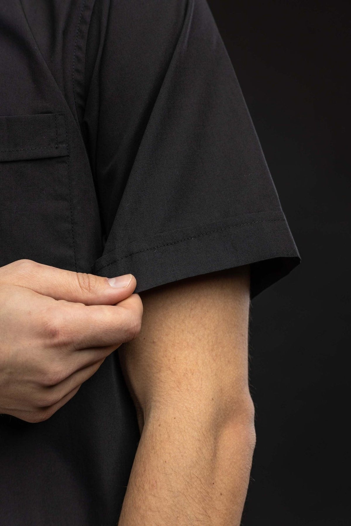 Black clergy shirt close-up showing the short-sleeve hem