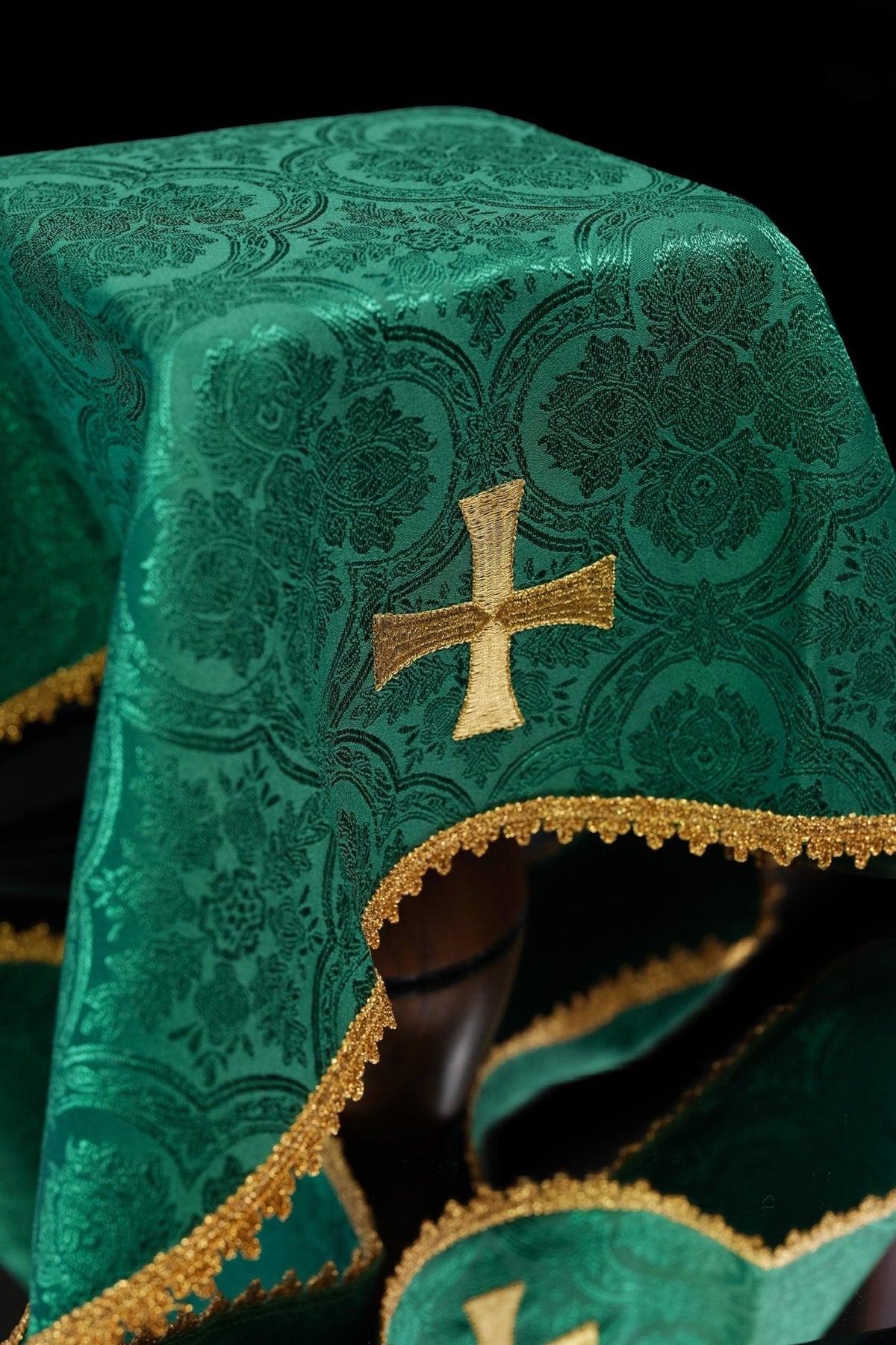 Green jacquard chalice veil close-up with gold embroidered cross and trim