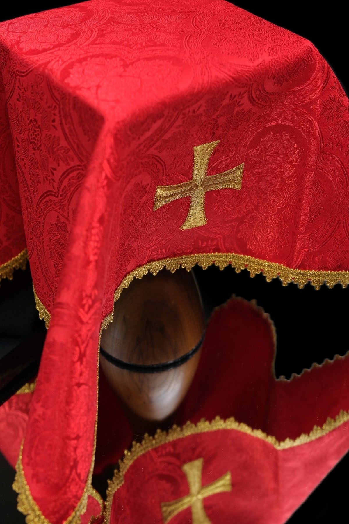 Red jacquard chalice veil close-up with gold embroidered cross and trim