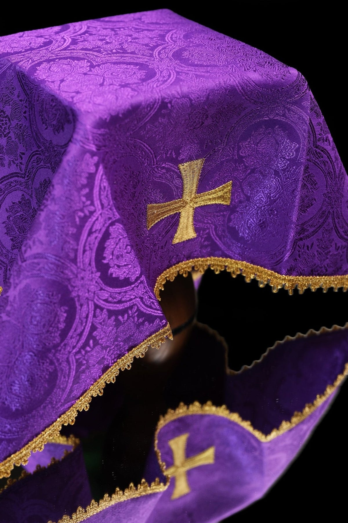 Purple jacquard chalice veil close-up with gold embroidered cross and trim