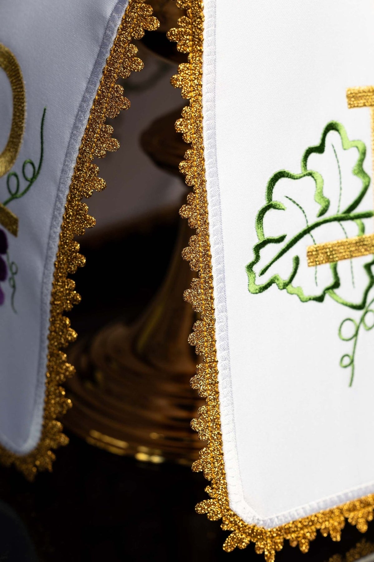 Ciborium veil detail showing gold decorative trim beside green vine embroidery