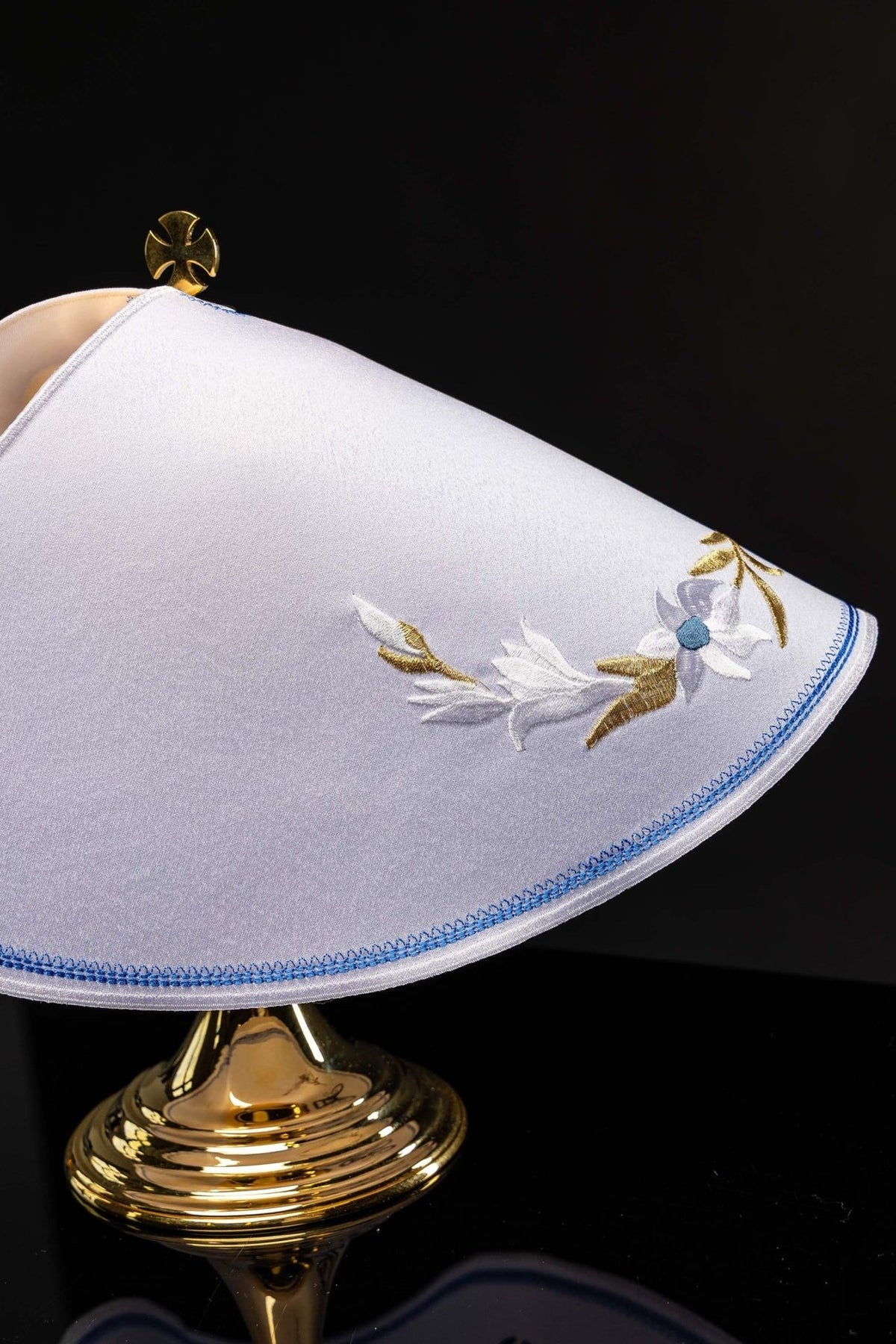 Ciborium veil close-up showing white and gold embroidered floral motif with light blue edging