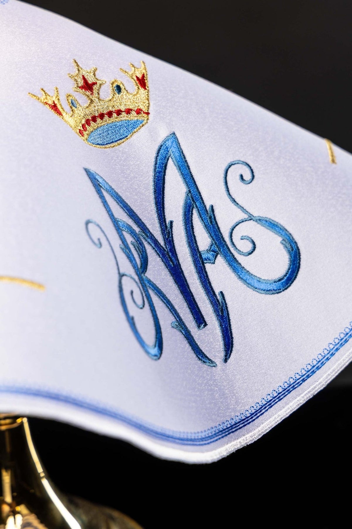 Ciborium veil close-up showing embroidered light blue Marian monogram, gold crown and edging