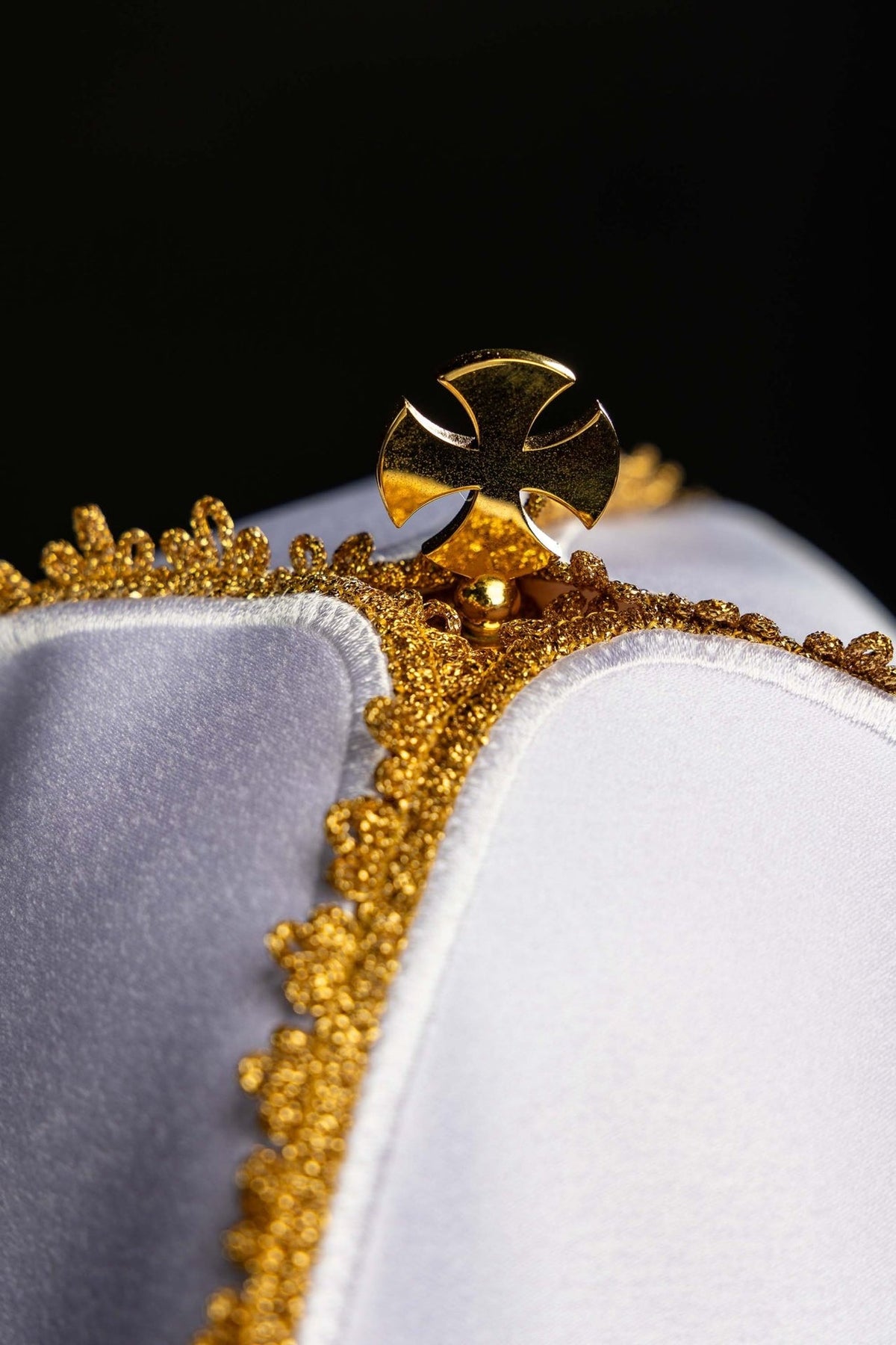Ciborium veil detail showing gold cross finial and ornate gold embroidery trim