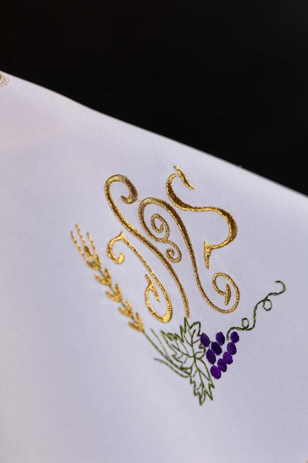 White ciborium veil close-up showing gold IHS with grapes and wheat embroidery