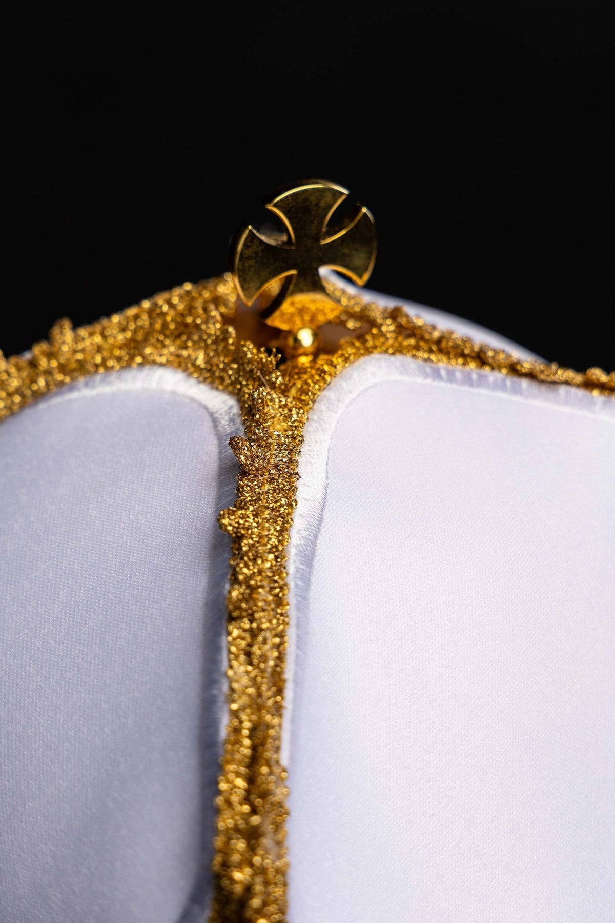 Ciborium veil close-up of white fabric, gold trim and cross detail