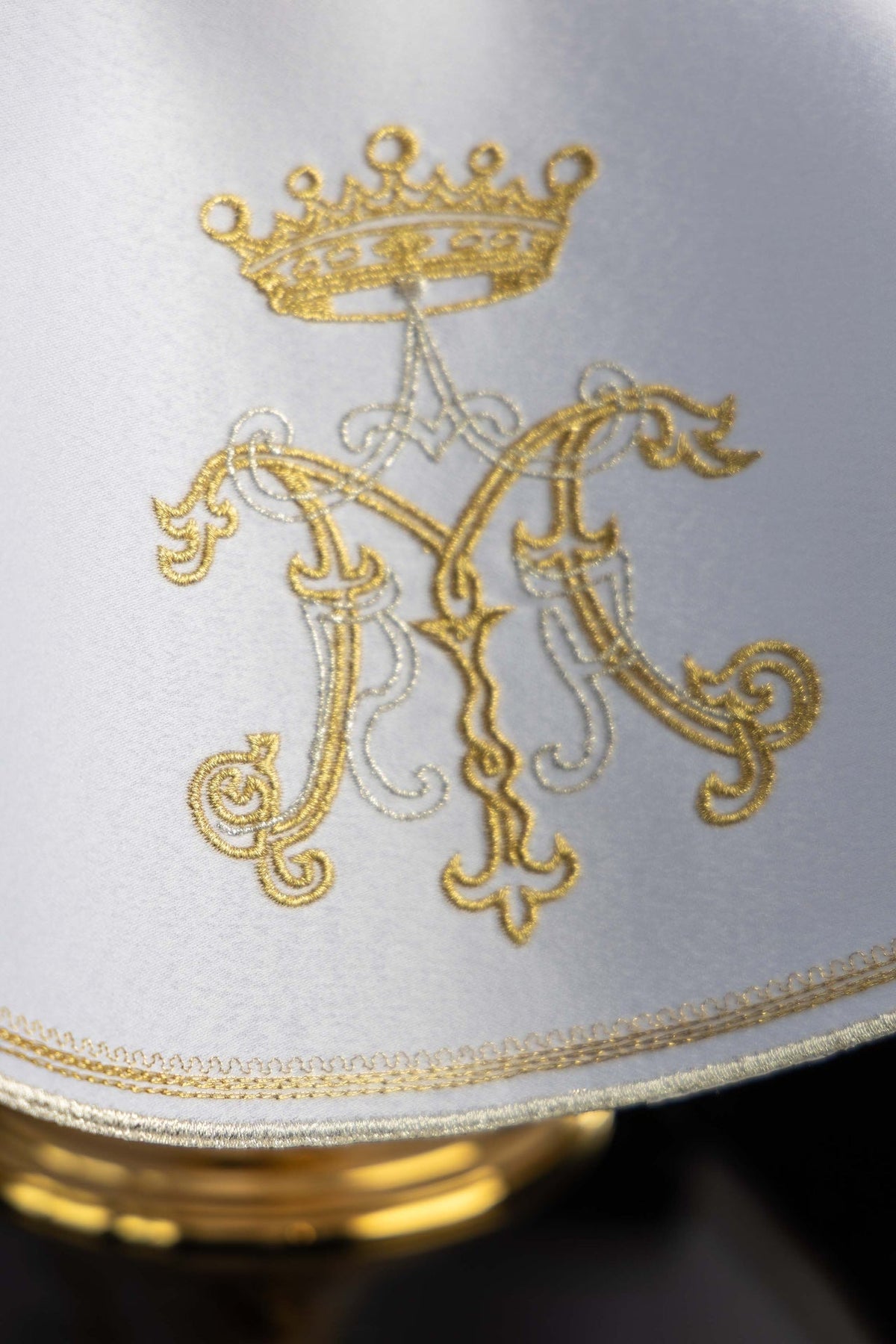 Ciborium veil close-up showing gold Marian embroidery and white fabric trim