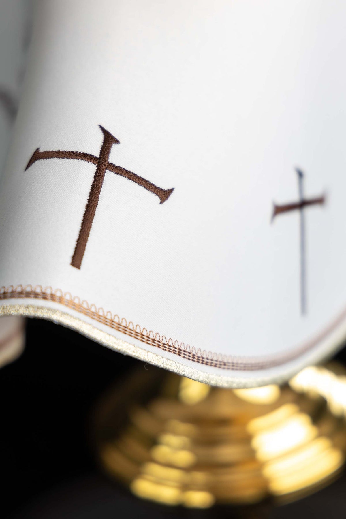 Ciborium veil close-up showing brown embroidered crosses and gold trim