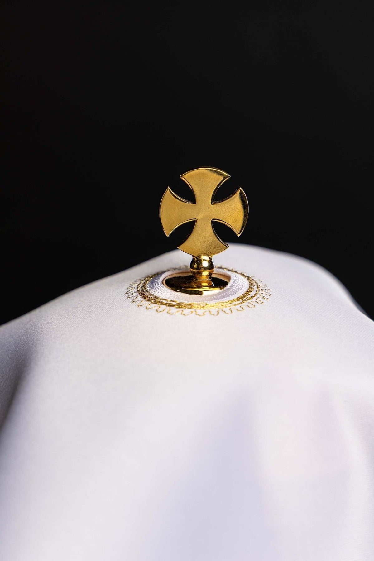 Ciborium veil close-up showing white top with gold cross fitting and embroidery