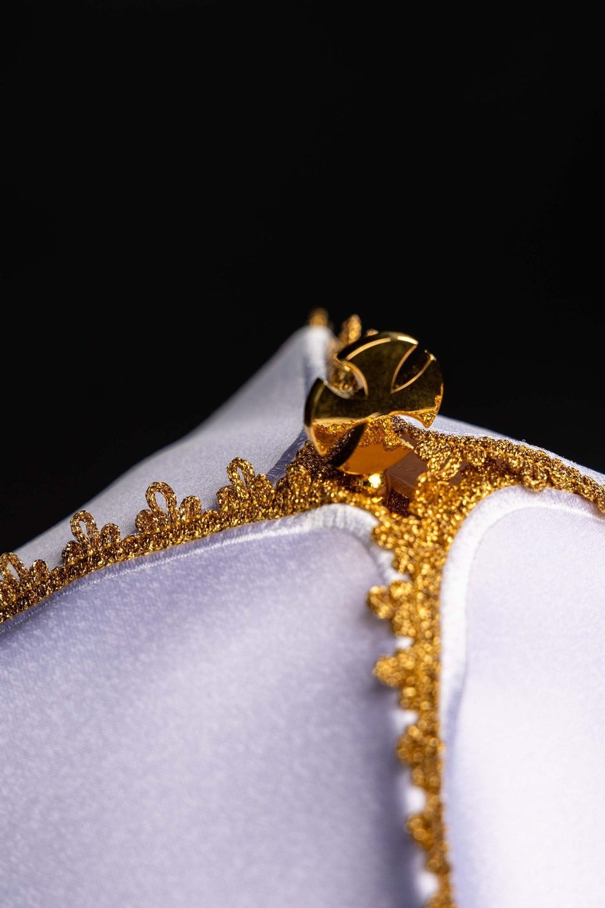 Ciborium veil close-up showing gold lace trim and cross fastening