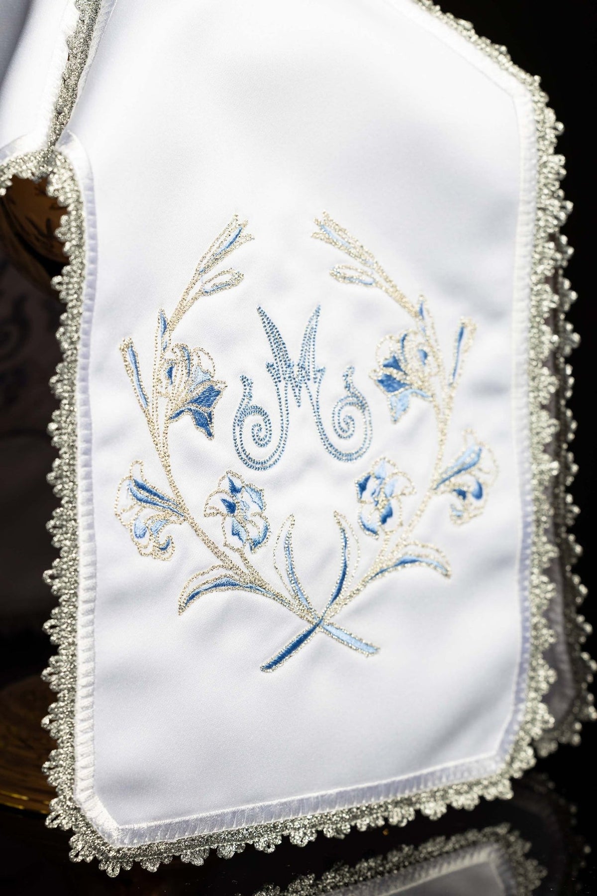 White ciborium veil close-up showing Marian embroidery and silver scalloped trim