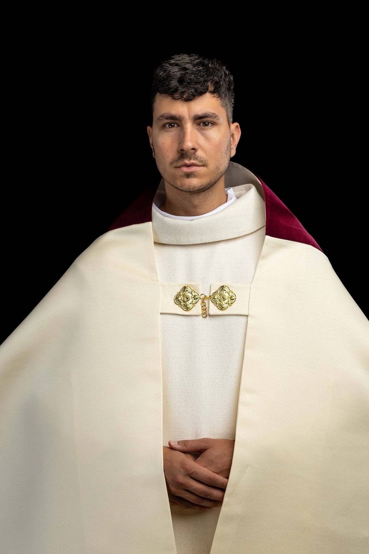 Humeral veil front view in ecru with gold clasp and burgundy velvet visible at the shoulders