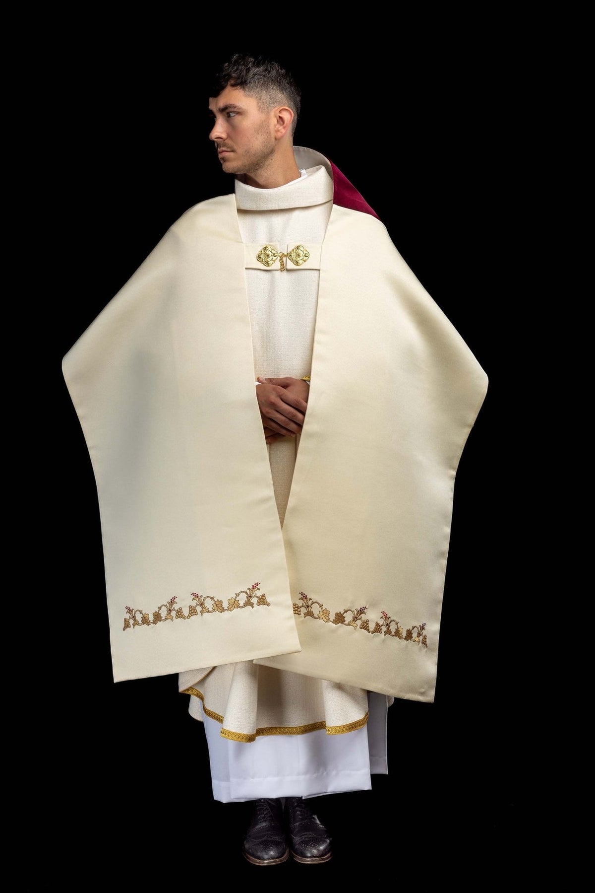 Humeral veil worn from the front, showing ecru fabric and gold vine embroidery