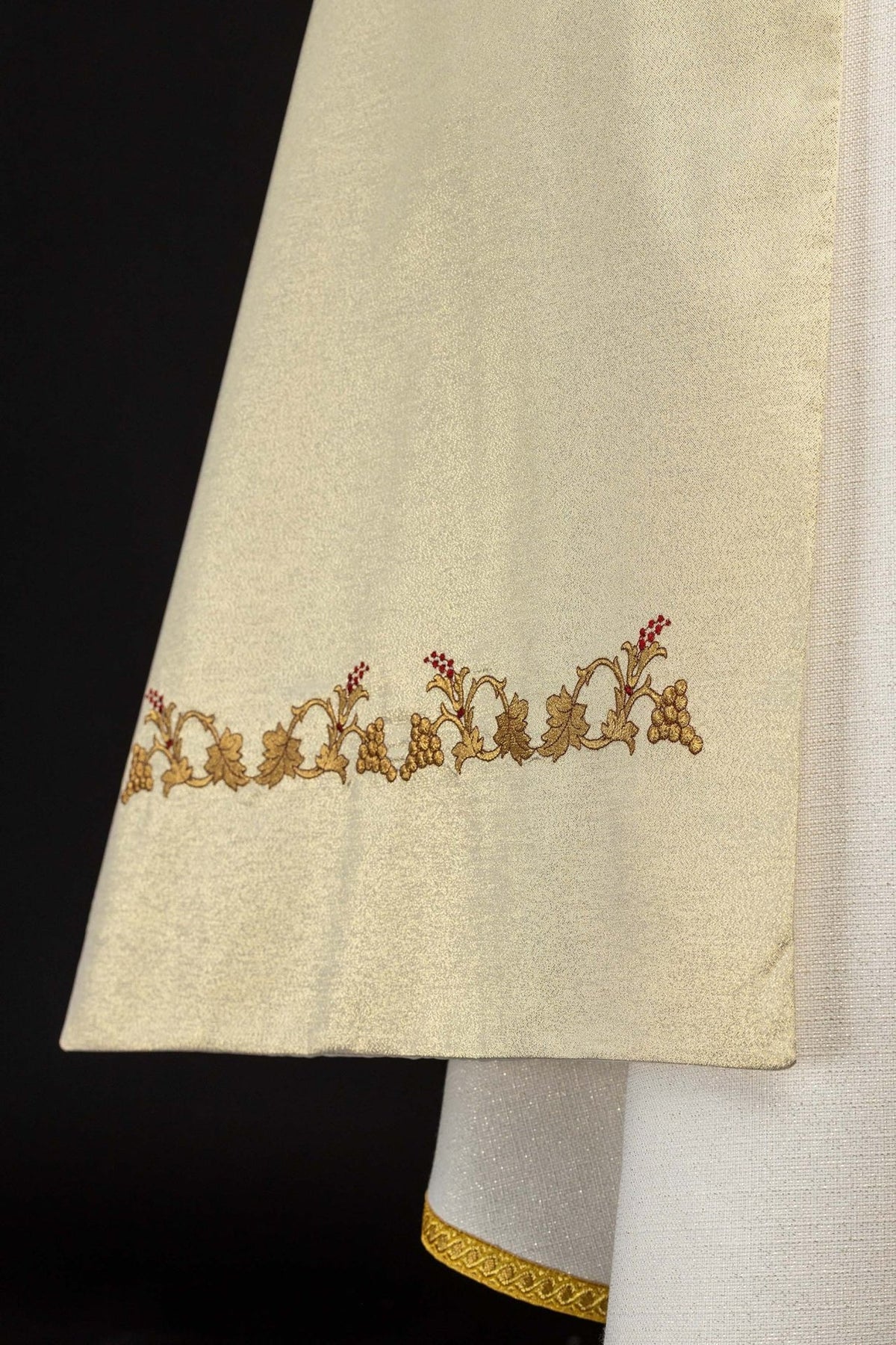 Gold humeral veil detail showing embroidered grapes and vine border