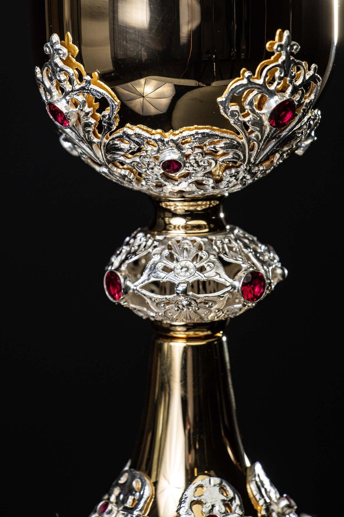 Gold-plated chalice close-up of ornate cup and stem with red decorative rubies
