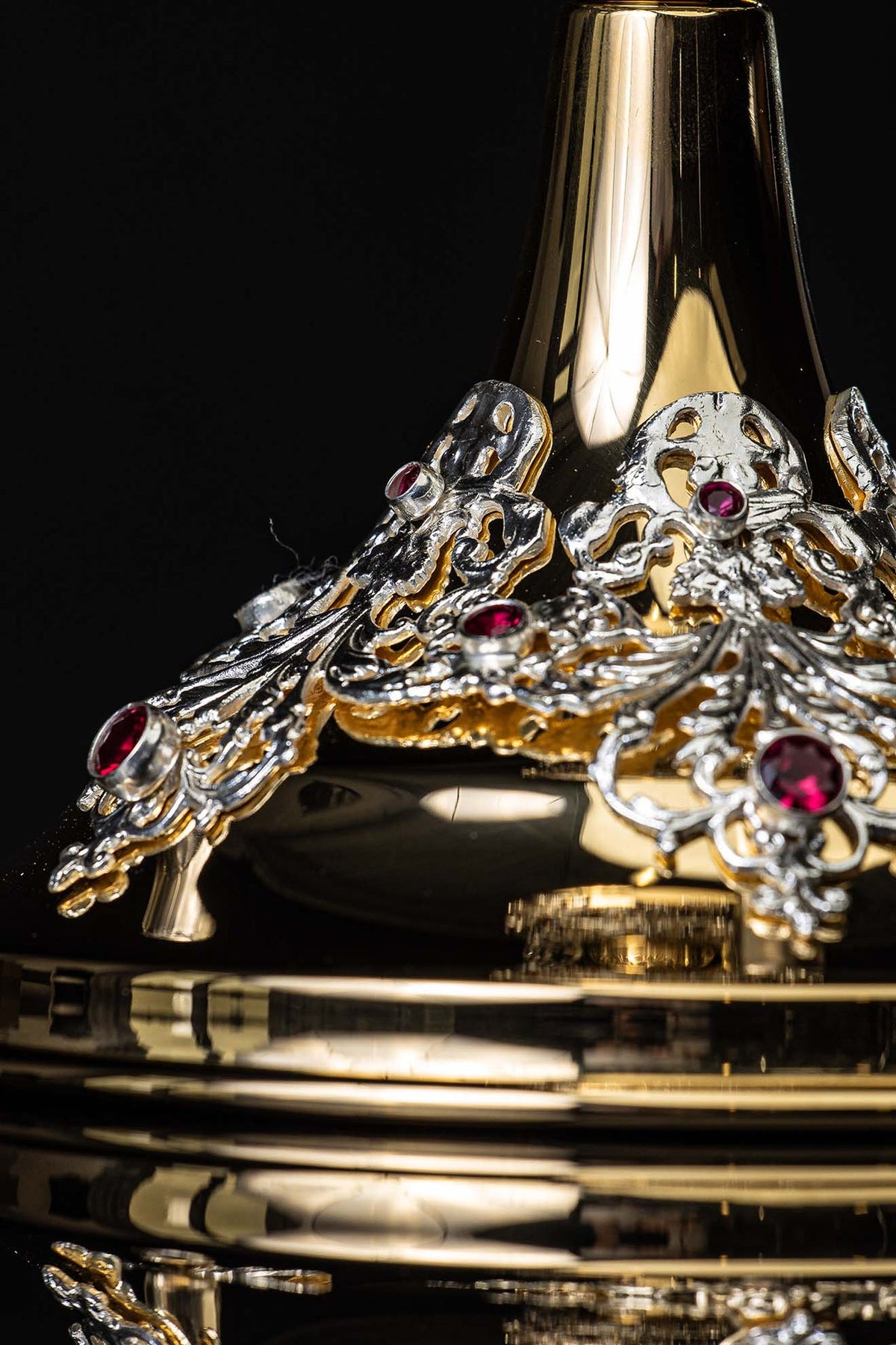 Gold-plated chalice close-up of handcrafted base ornament with red rubies